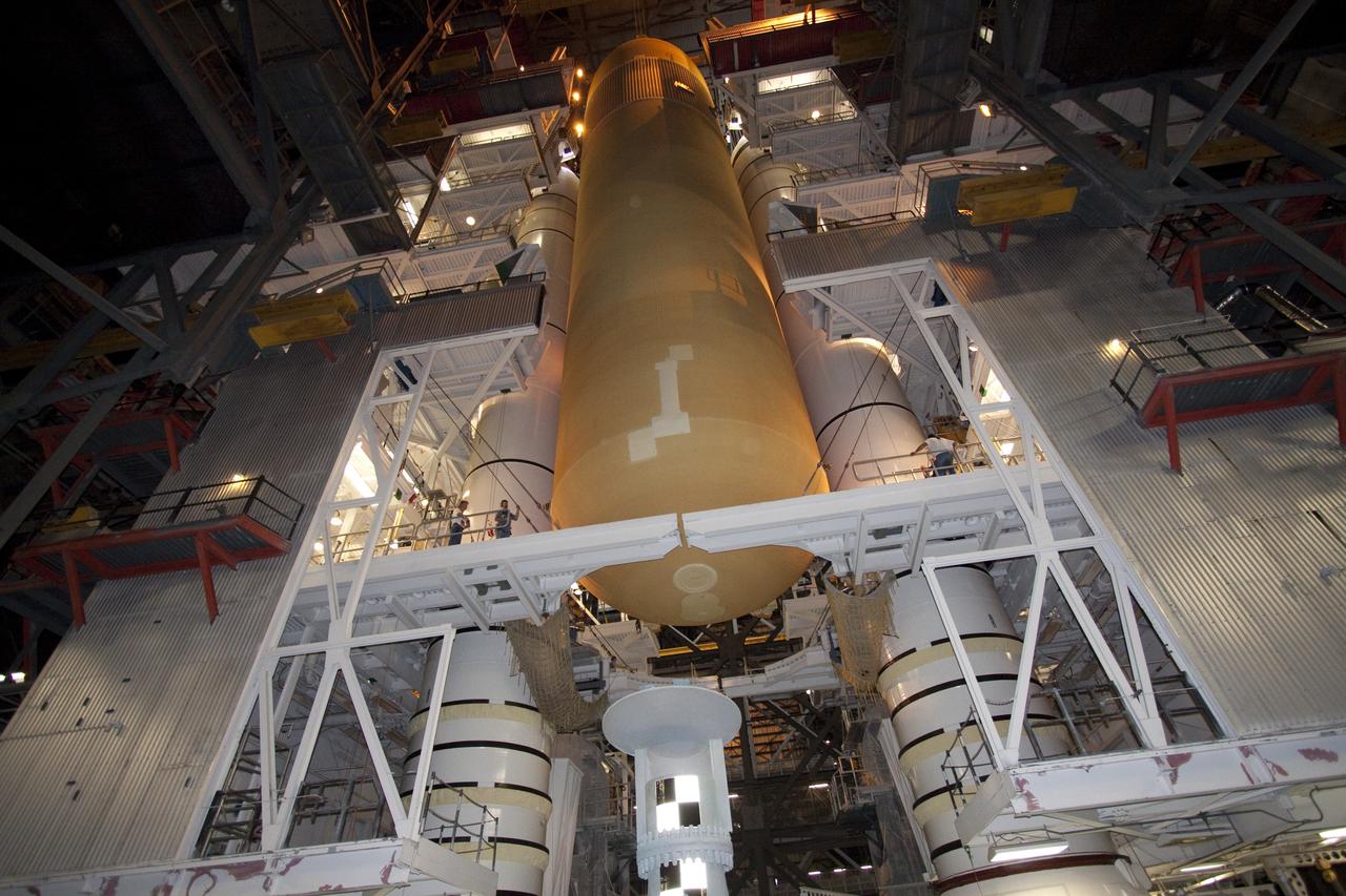 CAPE CANAVERAL, Fla. - In the Vehicle Assembly Building (VAB) at NASA's Kennedy Space Center in Florida, workers monitor the progress of external fuel tank, ET-138, for space shuttle Atlantis' STS-135 mission, as it is lowered into high bay-1 between the twin solid rocket boosters on the mobile launcher platform. Shuttle Atlantis' move, or "rollover," from Orbiter Processing Facility-1 to the VAB is targeted for May 10. Once there it will be mated with the external tank and boosters. Atlantis and its crew of four will deliver the Raffaello multipurpose logistics module packed with supplies and spare parts to the International Space Station. STS-135 is targeted to launch June 28, and will be the last spaceflight for the Space Shuttle Program. Photo credit: NASA/Jack Pfaller