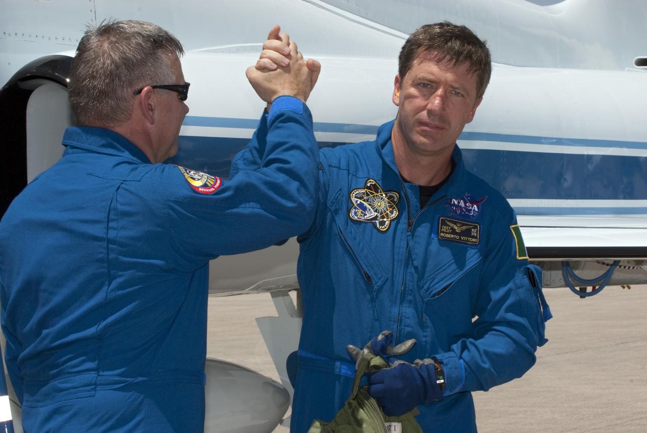 CAPE CANAVERAL, Fla. -- At NASA Kennedy Space Center's Shuttle Landing Facility in Florida, STS-134 crew members, Pilot Greg H. Johnson and European Space Agency astronaut Roberto Vittori greet each other upon arrival. The STS-134 crew landed at 12:52 p.m. EDT to prepare for shuttle Endeavour's launch to the International Space Station scheduled for Friday April 29 at 3:47 p.m. Endeavour and its crew will deliver the Express Logistics Carrier-3, Alpha Magnetic Spectrometer-2 (AMS), a high-pressure gas tank and additional spare parts for the Dextre robotic helper to the station. This will be the final spaceflight for Endeavour. For more information visit, www.nasa.gov/mission_pages/shuttle/shuttlemissions/sts134/index.html. Photo credit: NASA/Kim Shiflett