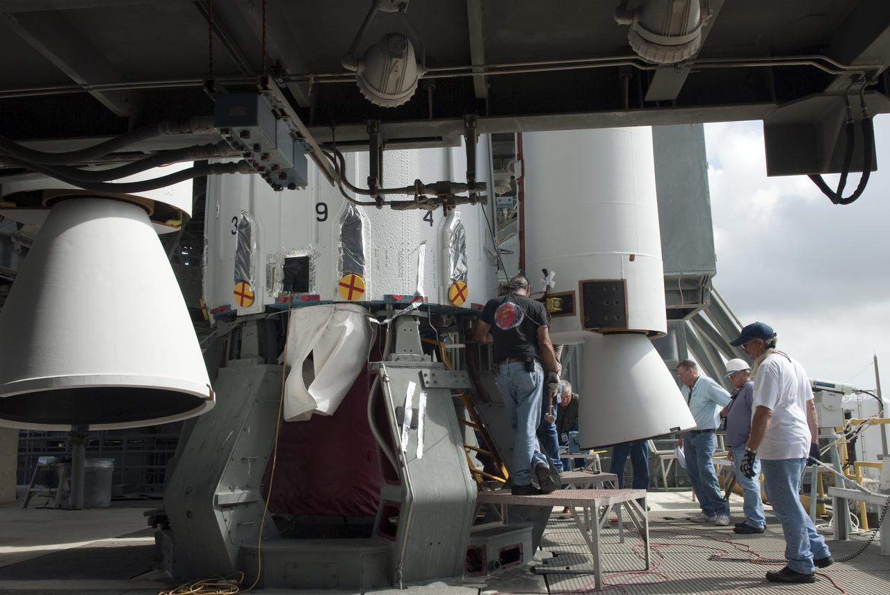 CAPE CANAVERAL, Fla. -- Technicians and engineers survey the connection of the first set of solid-fueled boosters to the first stage of a United Launch Alliance Delta II rocket. The boosters are being attached to the rocket at Launch Complex 17-B at Cape Canaveral Air Force Station in Florida. The Delta II will carry NASA's Gravity Recovery and Interior Laboratory, or GRAIL, spacecraft into lunar orbit. The GRAIL mission is a part of NASA's Discovery Program. GRAIL will fly twin spacecraft in tandem orbits around the moon for several months to measure its gravity field. The mission also will answer longstanding questions about Earth's moon and provide scientists a better understanding of how Earth and other rocky planets in the solar system formed. GRAIL is scheduled to launch September 8, 2011. For more information visit: http://science.nasa.gov/missions/grail/. Photo credit: NASA/Jim Grossmann