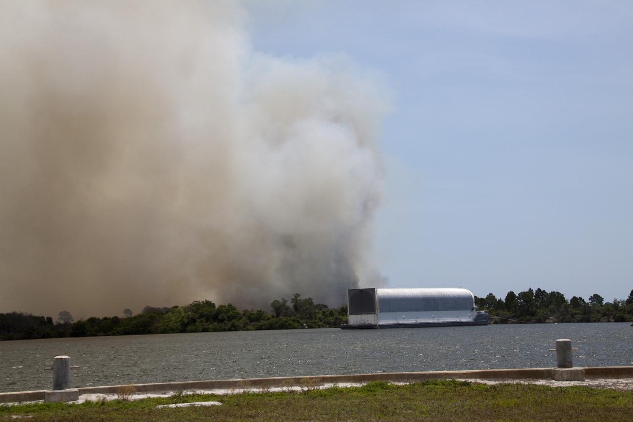 CAPE CANAVERAL, Fla. -- At NASA's Kennedy Space Center in Florida, smoke rises from a smoldering brush fire southeast of the Turn Basin. The fire was spotted near Kennedy’s Press Site approximately three miles away from Launch Pad 39A. The fires are being contained by firefighters from Kennedy Space Center and the U.S. Fish and Wildlife Service. No personnel are in danger and currently there is no to impact any operations related to space shuttle Endeavour’s launch countdown. Photo credit: NASA/Jack Pfaller