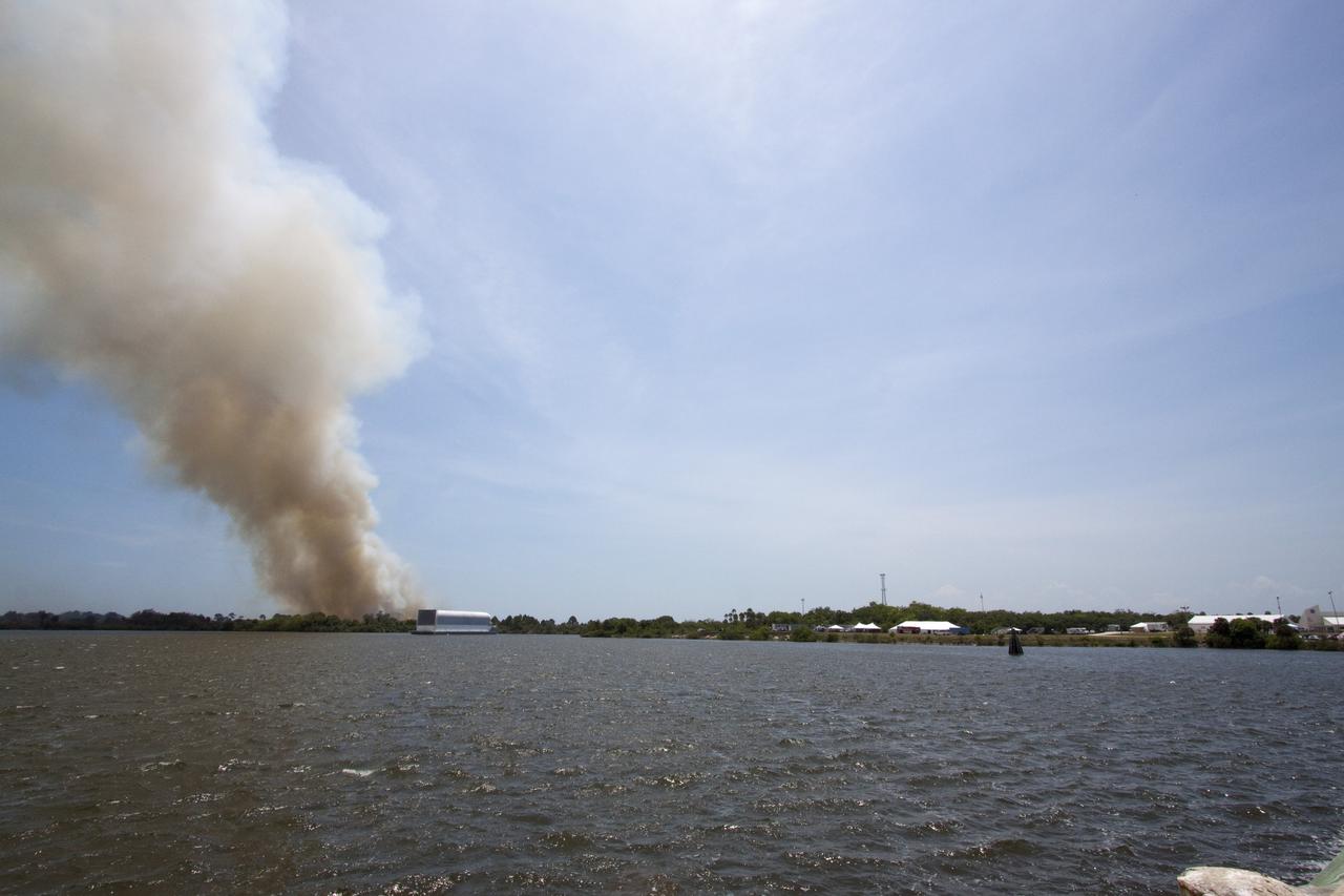 CAPE CANAVERAL, Fla. -- At NASA's Kennedy Space Center in Florida, smoke rises from a smoldering brush fire southeast of the Turn Basin. The fire was spotted near Kennedy’s Press Site approximately three miles away from Launch Pad 39A. The fires are being contained by firefighters from Kennedy Space Center and the U.S. Fish and Wildlife Service. No personnel are in danger and currently there is no to impact any operations related to space shuttle Endeavour’s launch countdown. Photo credit: NASA/Jack Pfaller