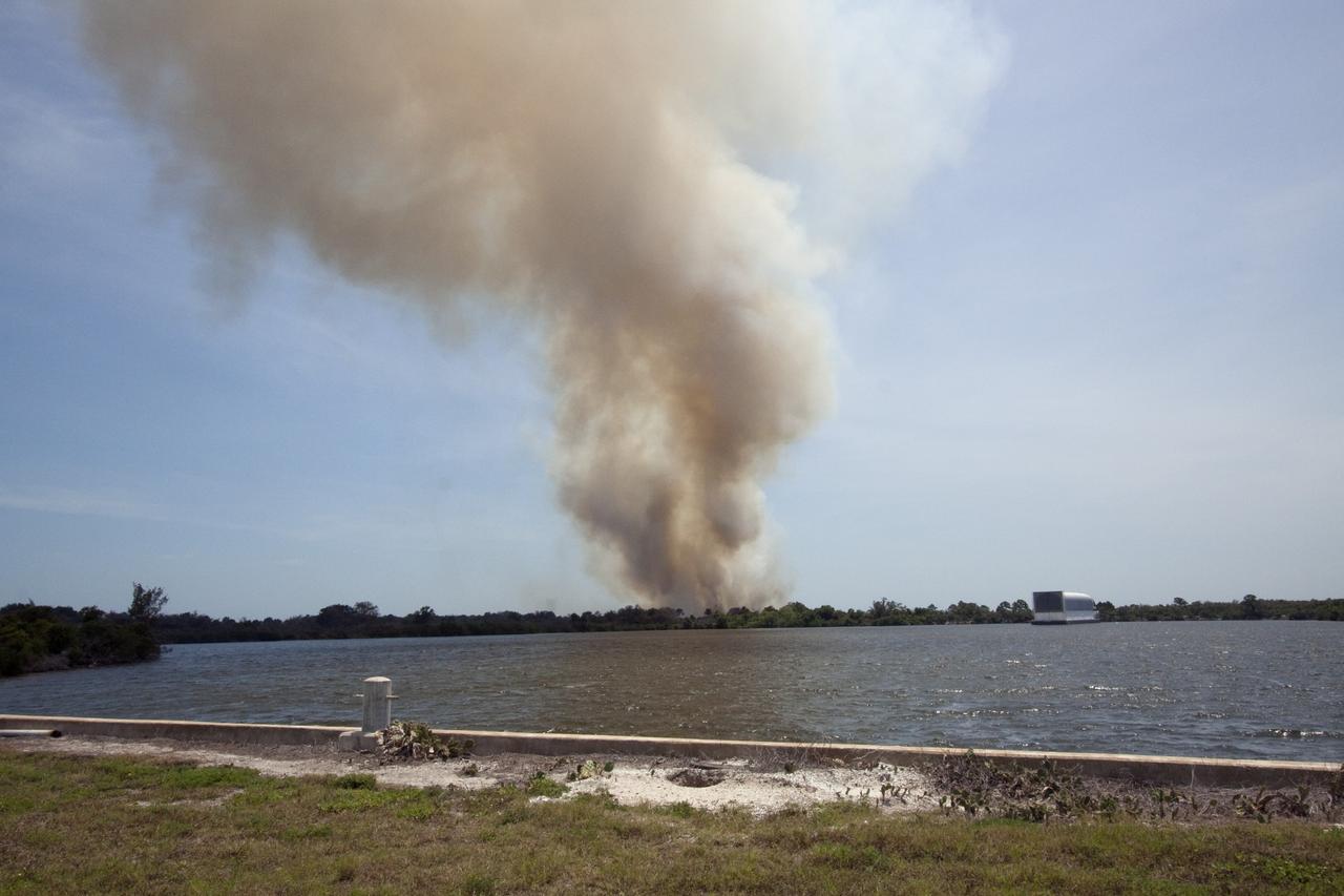 CAPE CANAVERAL, Fla. -- At NASA's Kennedy Space Center in Florida, smoke rises from a smoldering brush fire southeast of the Turn Basin. The fire was spotted near Kennedy’s Press Site approximately three miles away from Launch Pad 39A. The fires are being contained by firefighters from Kennedy Space Center and the U.S. Fish and Wildlife Service. No personnel are in danger and currently there is no to impact any operations related to space shuttle Endeavour’s launch countdown. Photo credit: NASA/Jack Pfaller