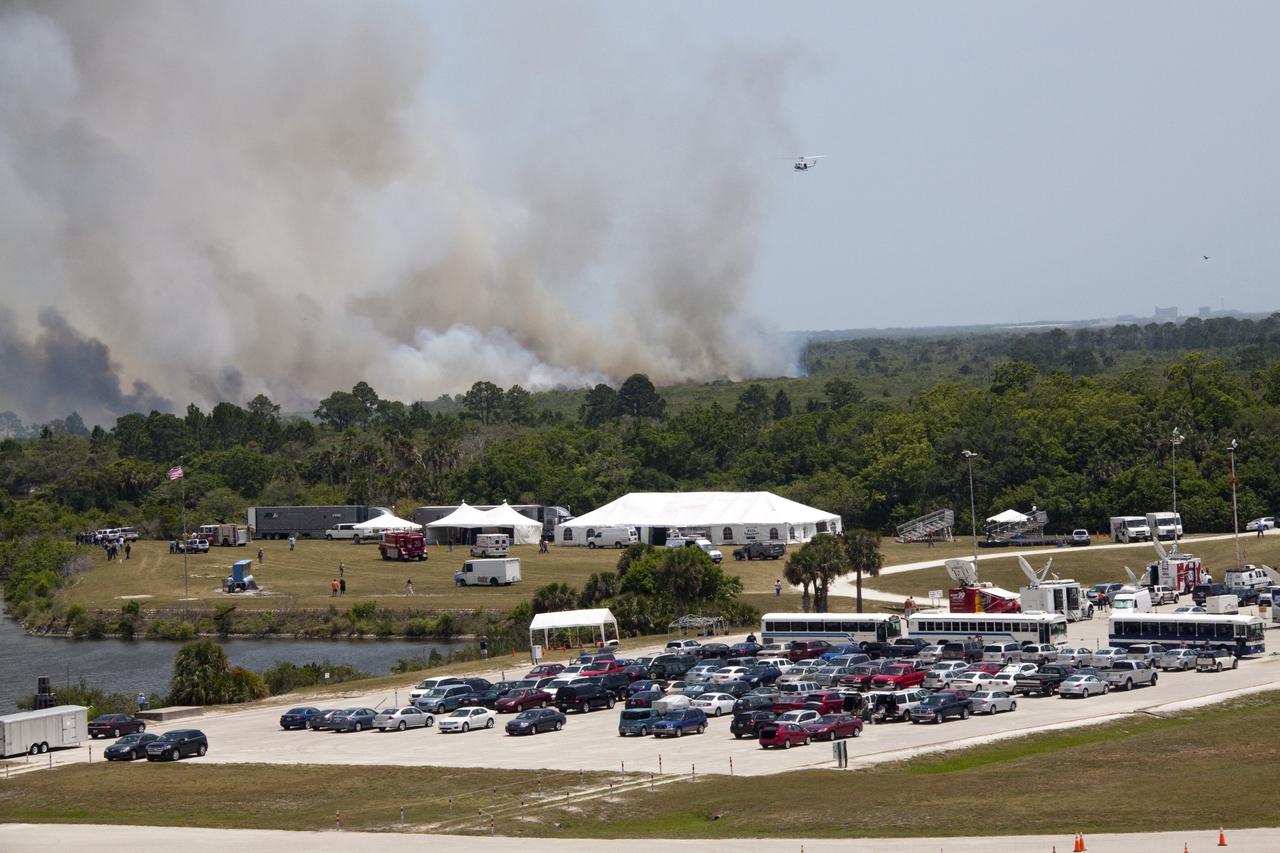 CAPE CANAVERAL, Fla. -- At NASA's Kennedy Space Center in Florida, smoke rises from a smoldering brush fire southeast of the Turn Basin. The fire was spotted near Kennedy’s Press Site approximately three miles away from Launch Pad 39A. The fires are being contained by firefighters from Kennedy Space Center and the U.S. Fish and Wildlife Service. No personnel are in danger and currently there is no to impact any operations related to space shuttle Endeavour’s launch countdown. Photo credit: NASA/Jack Pfaller