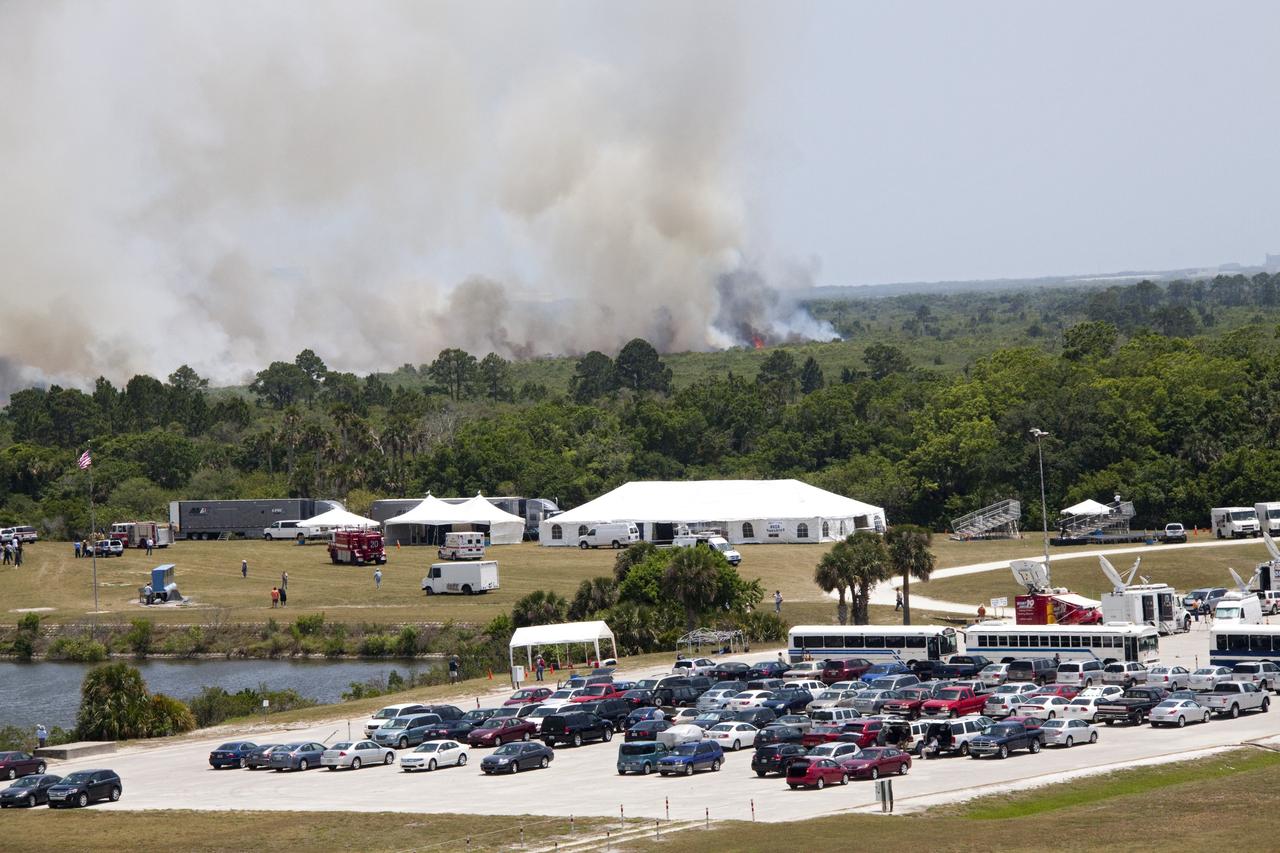 CAPE CANAVERAL, Fla. -- At NASA's Kennedy Space Center in Florida, smoke rises from a smoldering brush fire southeast of the Turn Basin. The fire was spotted near Kennedy’s Press Site approximately three miles away from Launch Pad 39A. The fires are being contained by firefighters from Kennedy Space Center and the U.S. Fish and Wildlife Service. No personnel are in danger and currently there is no to impact any operations related to space shuttle Endeavour’s launch countdown. Photo credit: NASA/Jack Pfaller