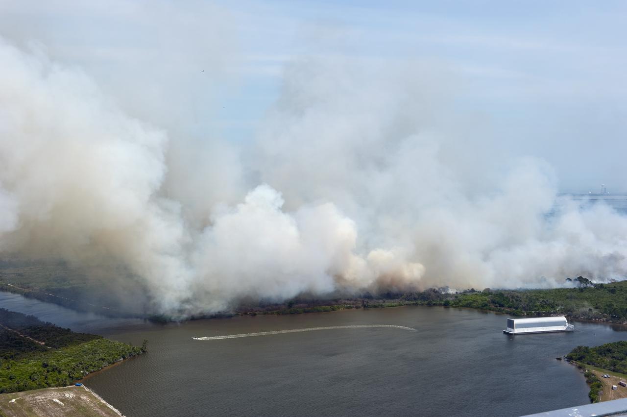 CAPE CANAVERAL, Fla. -- At NASA's Kennedy Space Center in Florida, smoke rises from a smoldering brush fire southeast of the Turn Basin. The fire was spotted near Kennedy’s Press Site approximately three miles away from Launch Pad 39A. The fires are being contained by firefighters from Kennedy Space Center and the U.S. Fish and Wildlife Service. No personnel are in danger and currently there is no to impact any operations related to space shuttle Endeavour’s launch countdown. Photo credit: NASA/Kim Shiflett