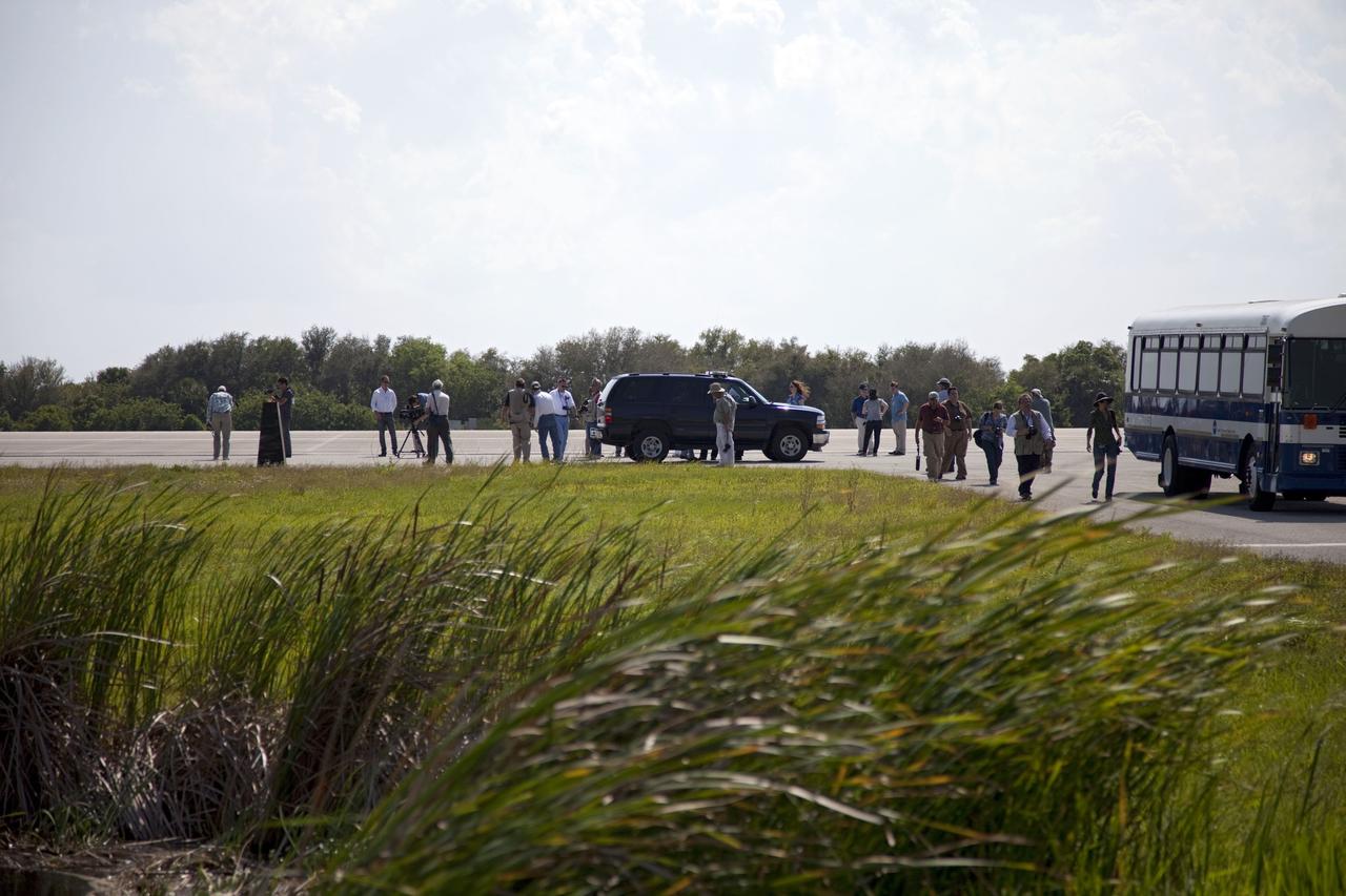 CAPE CANAVERAL, Fla. -- Media representatives participate in a Now and Future Tour at NASA's Kennedy Space Center in Florida. Here, they make a stop at the Shuttle Landing Facility's midfield to learn about the potential for private companies and government agencies to use the runway for a diversity of launch systems, including orbital and suborbital flights. Other stops along the tour included Launch Pad 39B and Orbiter Processing Facility-2 (OPF-2). Pad B is being restructured for future use. Its new design will feature a "clean pad" for rockets to come with their own launcher, making it more versatile for a number of vehicles. OPF-2 is where shuttle Discovery is being prepared for future public display at the Smithsonian's National Air and Space Museum Steven F. Udvar-Hazy Center in Chantilly, Va. Photo credit: NASA/Frankie Martin