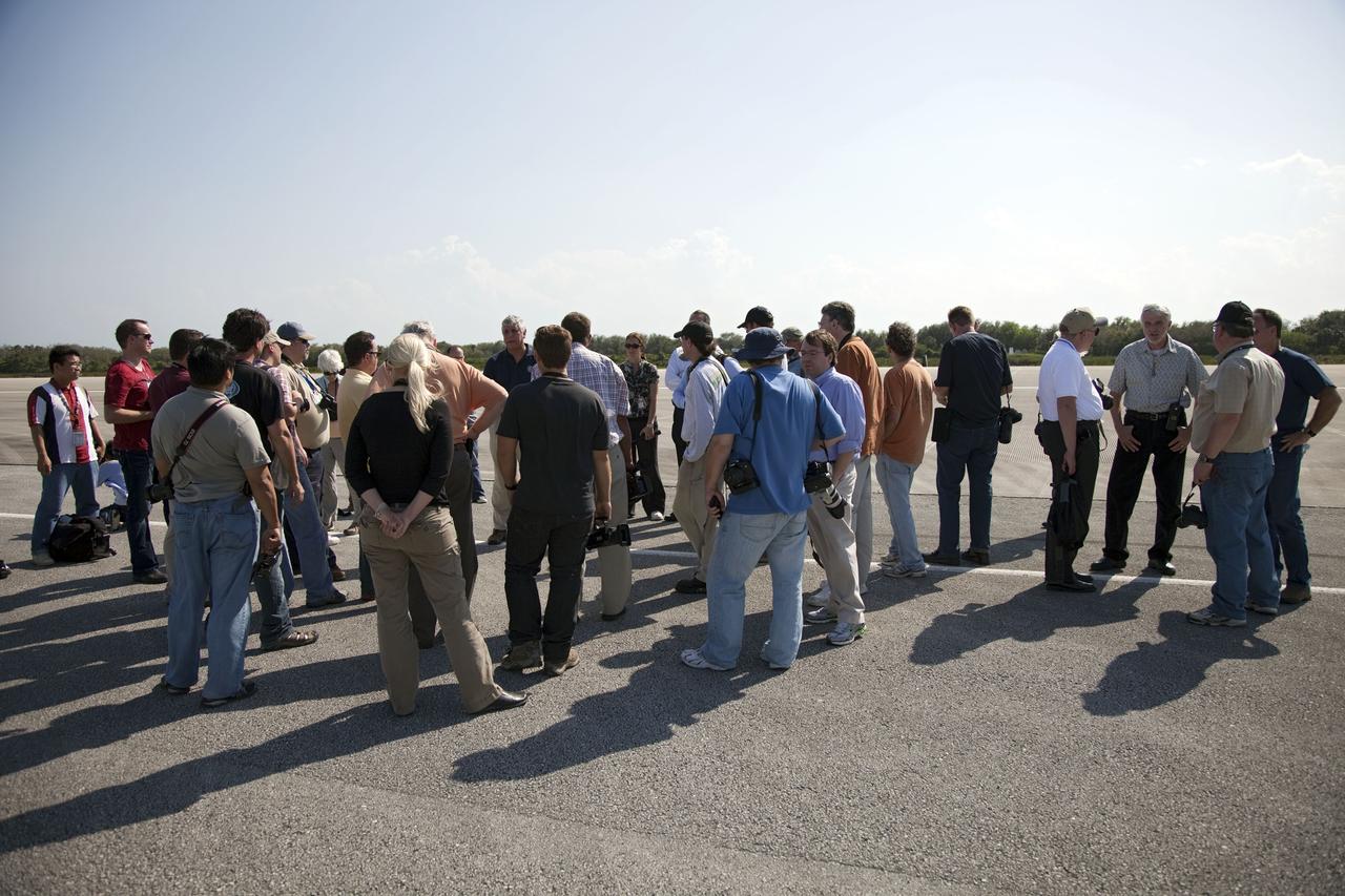 CAPE CANAVERAL, Fla. -- Media representatives participate in a Now and Future Tour at NASA's Kennedy Space Center in Florida. Here, they make a stop at the Shuttle Landing Facility's midfield to learn about the potential for private companies and government agencies to use the runway for a diversity of launch systems, including orbital and suborbital flights. Other stops along the tour included Launch Pad 39B and Orbiter Processing Facility-2 (OPF-2). Pad B is being restructured for future use. Its new design will feature a "clean pad" for rockets to come with their own launcher, making it more versatile for a number of vehicles. OPF-2 is where shuttle Discovery is being prepared for future public display at the Smithsonian's National Air and Space Museum Steven F. Udvar-Hazy Center in Chantilly, Va. Photo credit: NASA/Frankie Martin