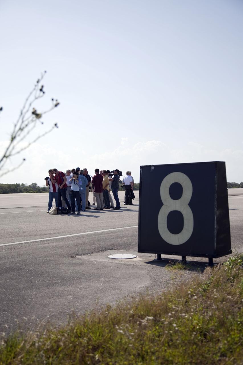 CAPE CANAVERAL, Fla. -- Media representatives participate in a Now and Future Tour at NASA's Kennedy Space Center in Florida. Here, they make a stop at the Shuttle Landing Facility's midfield to learn about the potential for private companies and government agencies to use the runway for a diversity of launch systems, including orbital and suborbital flights. Other stops along the tour included Launch Pad 39B and Orbiter Processing Facility-2 (OPF-2). Pad B is being restructured for future use. Its new design will feature a "clean pad" for rockets to come with their own launcher, making it more versatile for a number of vehicles. OPF-2 is where shuttle Discovery is being prepared for future public display at the Smithsonian's National Air and Space Museum Steven F. Udvar-Hazy Center in Chantilly, Va. Photo credit: NASA/Frankie Martin