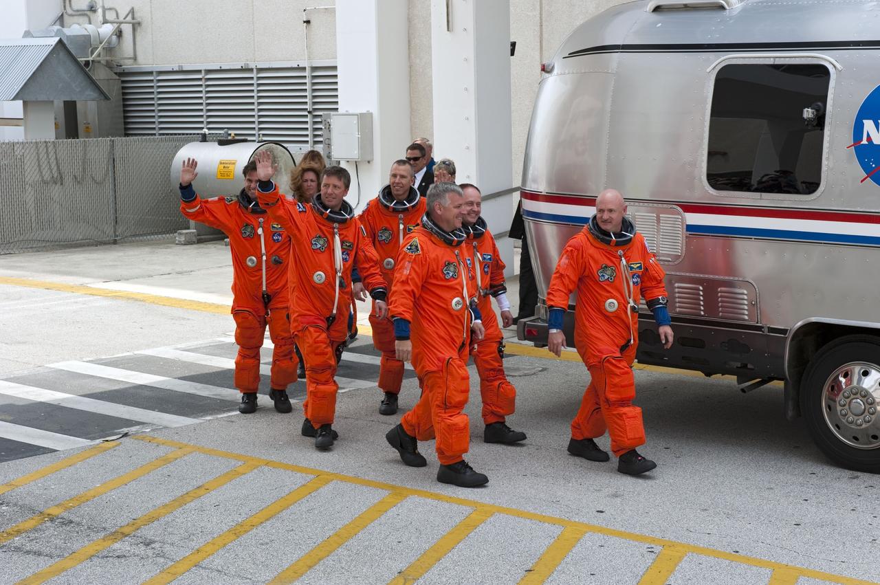 CAPE CANAVERAL, Fla. -- Space shuttle Endeavour's six STS-134 astronauts, dressed in their orange launch-and-entry suits, wave to news media and other spectators as they walk toward the Astrovan parked in front of the Operations and Checkout Building at NASA's Kennedy Space Center in Florida. The modified Airstream recreational vehicle has transported astronauts to their spacecraft since 1984. Leading the way is Commander Mark Kelly, followed by crewmates Greg H. Johnson, Michael Fincke, Andrew Feustel, Roberto Vittori with the European Space Agency and Greg Chamitoff. STS-134 will deliver the Express Logistics Carrier-3, Alpha Magnetic Spectrometer-2 (AMS), a high-pressure gas tank and additional spare parts for the Dextre robotic helper to the space station. Endeavour was scheduled to launch at 3:47 p.m. on April 29, but that attempt was scrubbed for at least 72 hours while engineers assess an issue associated with the shuttle's Auxiliary Power Unit 1. STS-134 will be the final spaceflight for Endeavour. For more information visit, www.nasa.gov/mission_pages/shuttle/shuttlemissions/sts134/index.html. Photo credit: NASA/Kim Shiflett