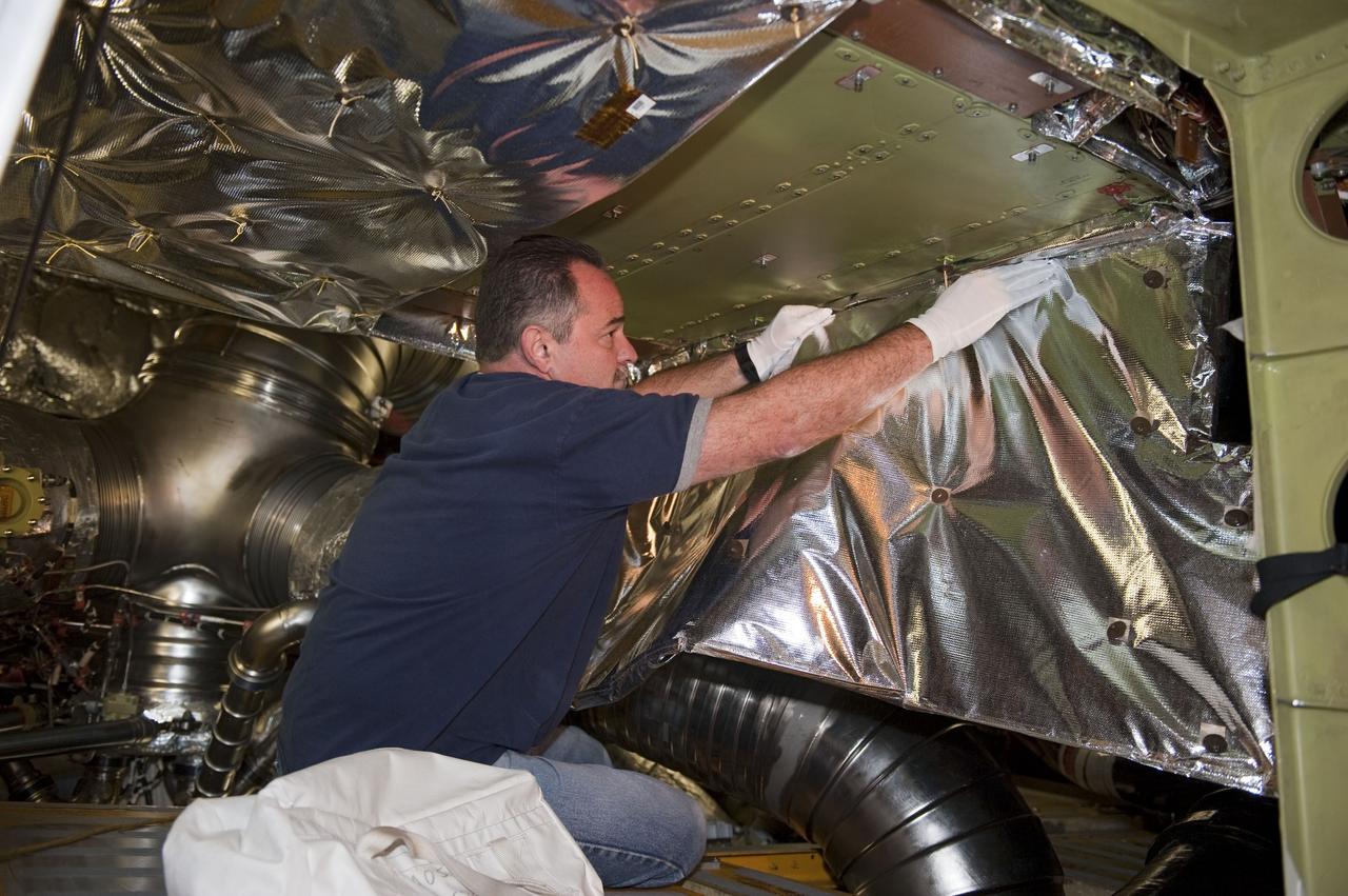 CAPE CANAVERAL, Fla. -- At NASA Kennedy Space Center's Launch Pad 39A, a worker inside space shuttle Endeavour's aft section removes an insulating blanket and cover to provide access for the removal and replacement of the Load Control Assembly-2 (LCA-2).        Located in the orbiter's aft avionics bay 5, the LCA-2 assembly, which feeds power to the fuel line heaters, is believed to have caused the heaters for Endeavour's auxiliary power unit-1 (APU-1) to fail April 29 during the first launch attempt for the STS-134 mission. STS-134 will deliver the Express Logistics Carrier-3, Alpha Magnetic Spectrometer-2 (AMS), a high-pressure gas tank and additional spare parts for the Dextre robotic helper to the International Space Station. The mission also will be the final spaceflight for Endeavour. For more information, visit www.nasa.gov/mission_pages/shuttle/shuttlemissions/sts134/index.html. Photo credit: NASA/Kim Shiflett.