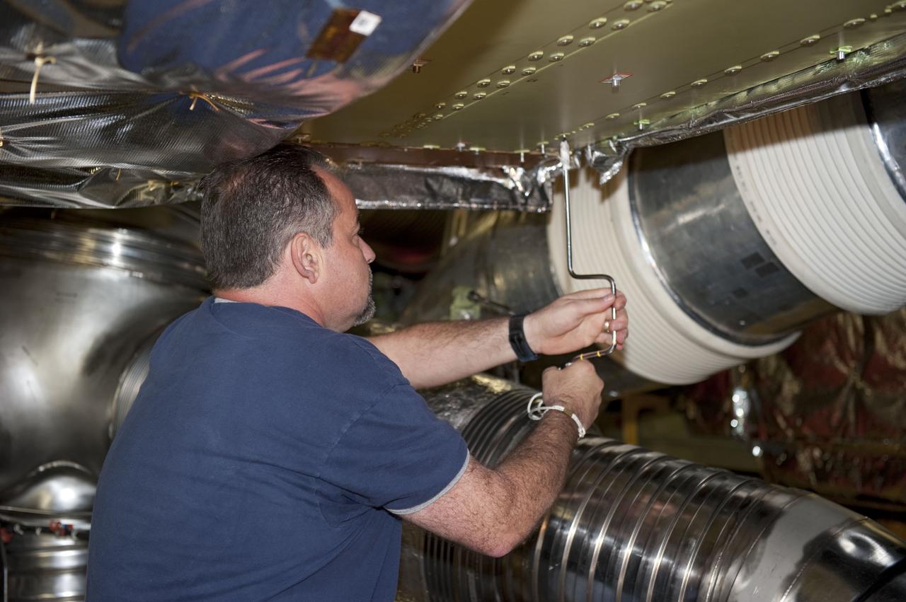 CAPE CANAVERAL, Fla. -- At NASA Kennedy Space Center's Launch Pad 39A, a worker inside space shuttle Endeavour's aft section removes a cover to provide access for the removal and replacement of the Load Control Assembly-2 (LCA-2).      Located in the orbiter's aft avionics bay 5, the LCA-2 assembly, which feeds power to the fuel line heaters, is believed to have caused the heaters for Endeavour's auxiliary power unit-1 (APU-1) to fail April 29 during the first launch attempt for the STS-134 mission. STS-134 will deliver the Express Logistics Carrier-3, Alpha Magnetic Spectrometer-2 (AMS), a high-pressure gas tank and additional spare parts for the Dextre robotic helper to the International Space Station. The mission also will be the final spaceflight for Endeavour. For more information, visit www.nasa.gov/mission_pages/shuttle/shuttlemissions/sts134/index.html. Photo credit: NASA/Kim Shiflett.