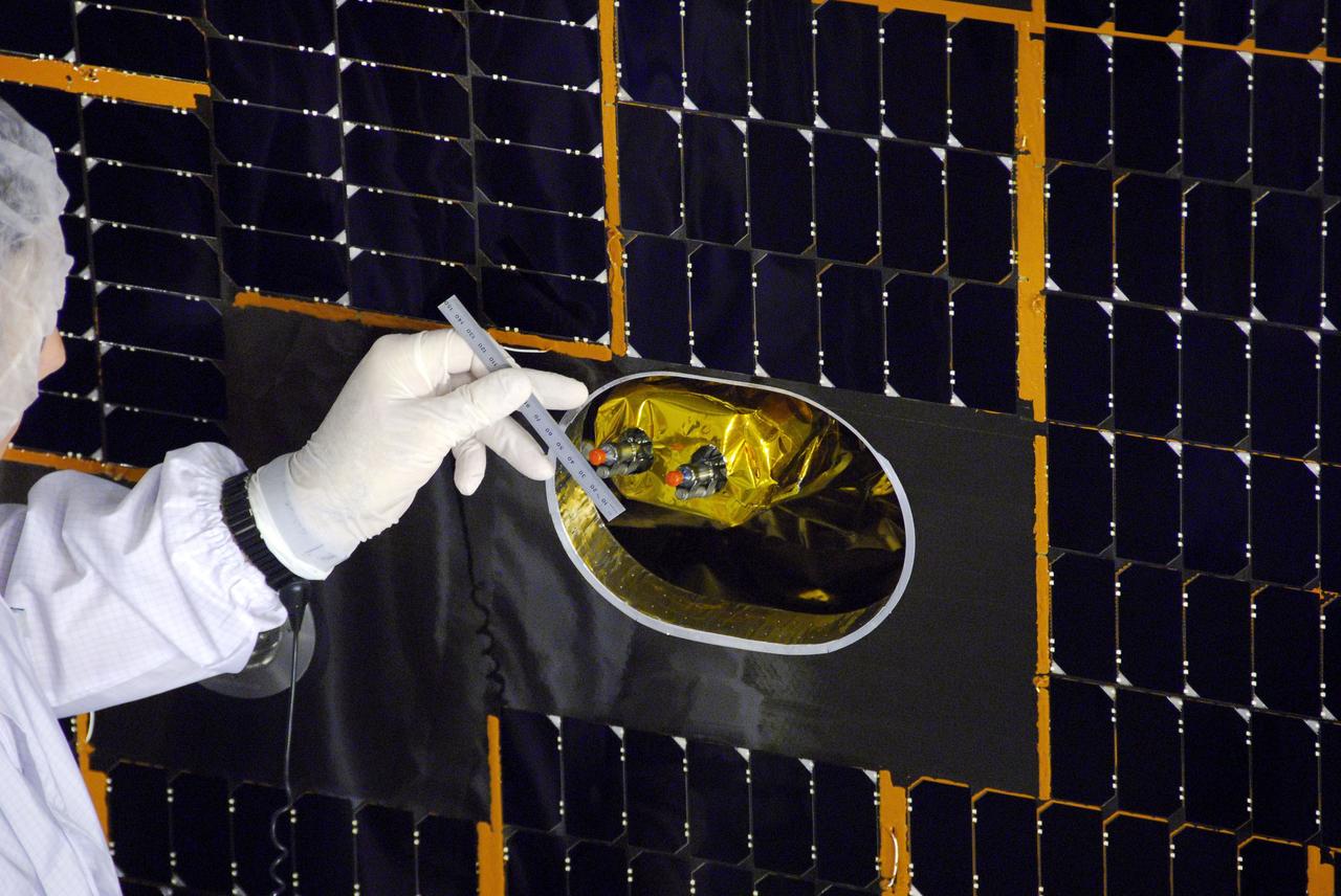 VANDENBERG AIR FORCE BASE, Calif. -- In Space Systems International's Payload Processing Facility at Vandenberg Air Force Base in California, a technician measures the clearance between the solar panel and a dual-thruster module after the array was installed to the Aquarius/SAC-D spacecraft.   Following final tests, the spacecraft will be integrated to a United Launch Alliance Delta II rocket in preparation for the targeted June launch. Aquarius, the NASA-built primary instrument on the SAC-D spacecraft, will provide new insights into how variations in ocean surface salinity relate to fundamental climate processes on its three-year mission. Photo credit: NASA/VAFB