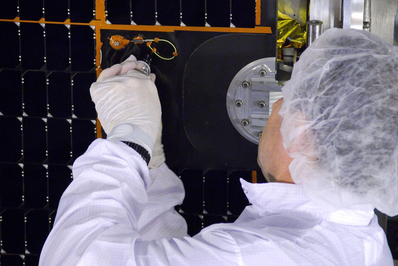 VANDENBERG AIR FORCE BASE, Calif. -- In Space Systems International's Payload Processing Facility at Vandenberg Air Force Base in California, a technician makes an adjustment to the solar array after it was installed to the Aquarius/SAC-D spacecraft.   Following final tests, the spacecraft will be integrated to a United Launch Alliance Delta II rocket in preparation for the targeted June launch. Aquarius, the NASA-built primary instrument on the SAC-D spacecraft, will provide new insights into how variations in ocean surface salinity relate to fundamental climate processes on its three-year mission. Photo credit: NASA/VAFB