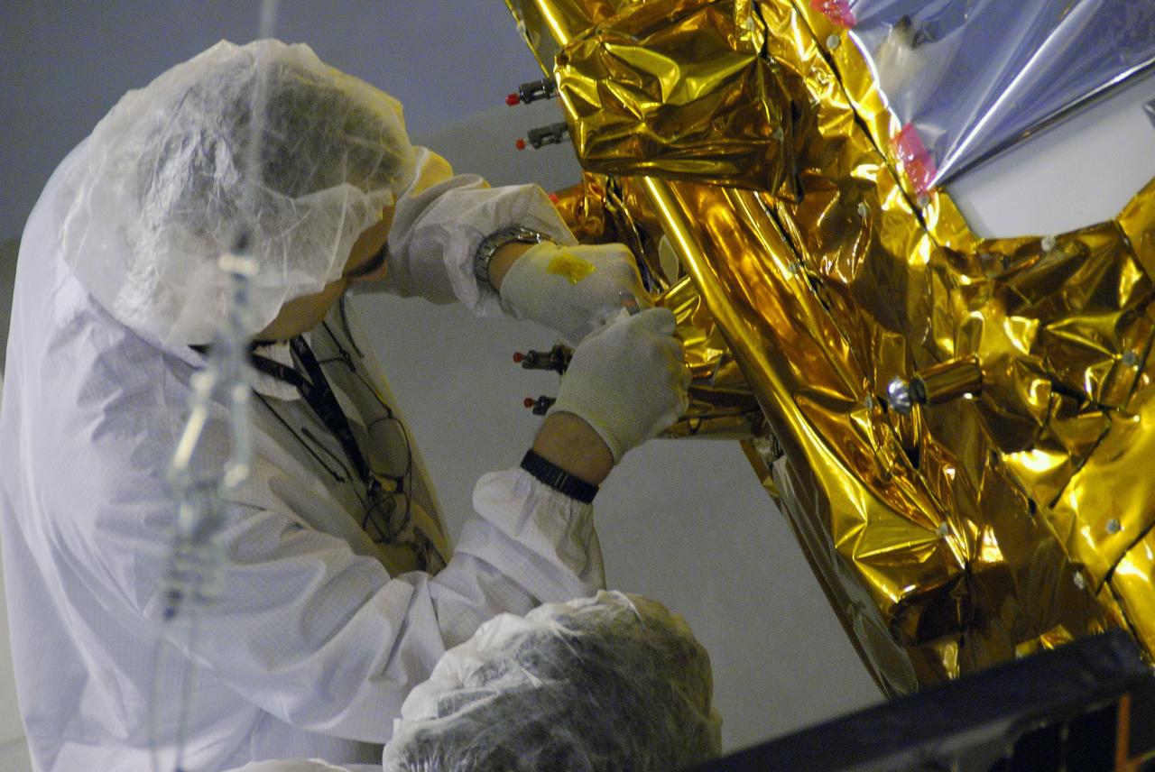 VANDENBERG AIR FORCE BASE, Calif. -- In Space Systems International's Payload Processing Facility at Vandenberg Air Force Base in California, a technician makes an adjustment to a solar array control on the Aquarius/SAC-D spacecraft during deployment testing.   Following final tests, the spacecraft will be integrated to a United Launch Alliance Delta II rocket in preparation for the targeted June launch. Aquarius, the NASA-built primary instrument on the SAC-D spacecraft, will provide new insights into how variations in ocean surface salinity relate to fundamental climate processes on its three-year mission. Photo credit: NASA/VAFB