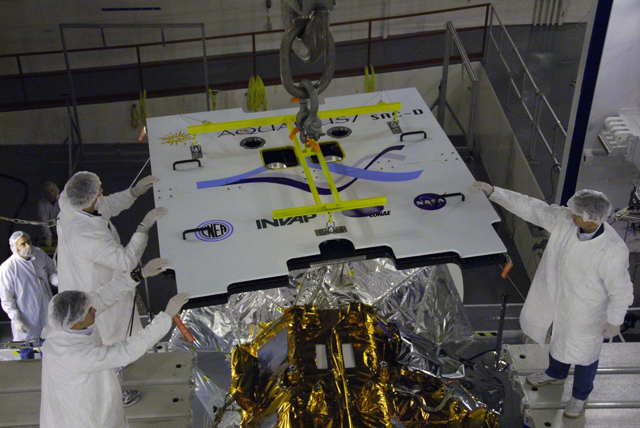 VANDENBERG AIR FORCE BASE, Calif. -- In Space Systems International's Payload Processing Facility at Vandenberg Air Force Base in California, technicians guide an overhead crane lowering the second solar array toward the Aquarius/SAC-D spacecraft.  Following final tests, the spacecraft will be integrated to a United Launch Alliance Delta II rocket in preparation for the targeted June launch. Aquarius, the NASA-built primary instrument on the SAC-D spacecraft, will provide new insights into how variations in ocean surface salinity relate to fundamental climate processes on its three-year mission. Photo credit: NASA/VAFB