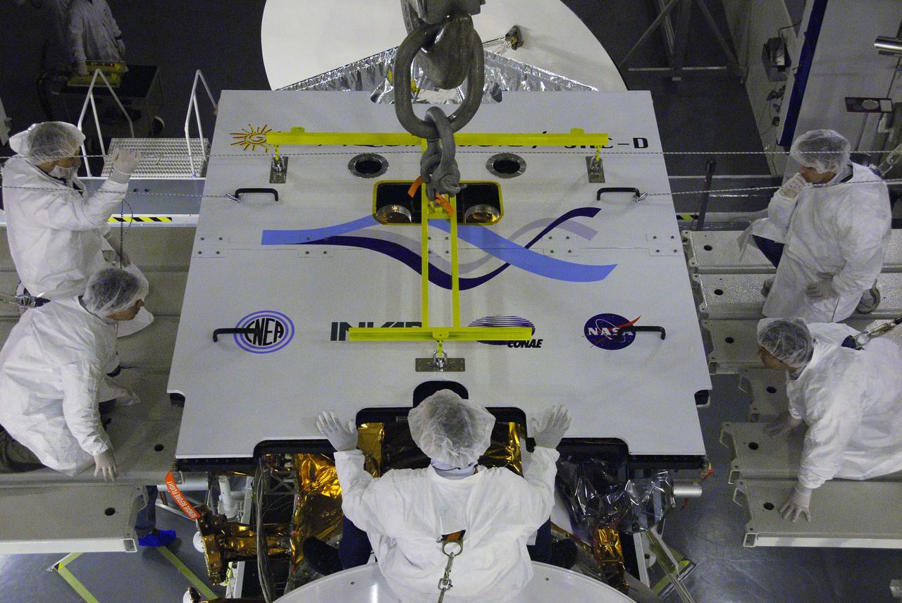 VANDENBERG AIR FORCE BASE, Calif. -- In Space Systems International's Payload Processing Facility at Vandenberg Air Force Base in California, technicians guide an overhead crane lowering the second solar array toward the Aquarius/SAC-D spacecraft.  Following final tests, the spacecraft will be integrated to a United Launch Alliance Delta II rocket in preparation for the targeted June launch. Aquarius, the NASA-built primary instrument on the SAC-D spacecraft, will provide new insights into how variations in ocean surface salinity relate to fundamental climate processes on its three-year mission. Photo credit: NASA/VAFB