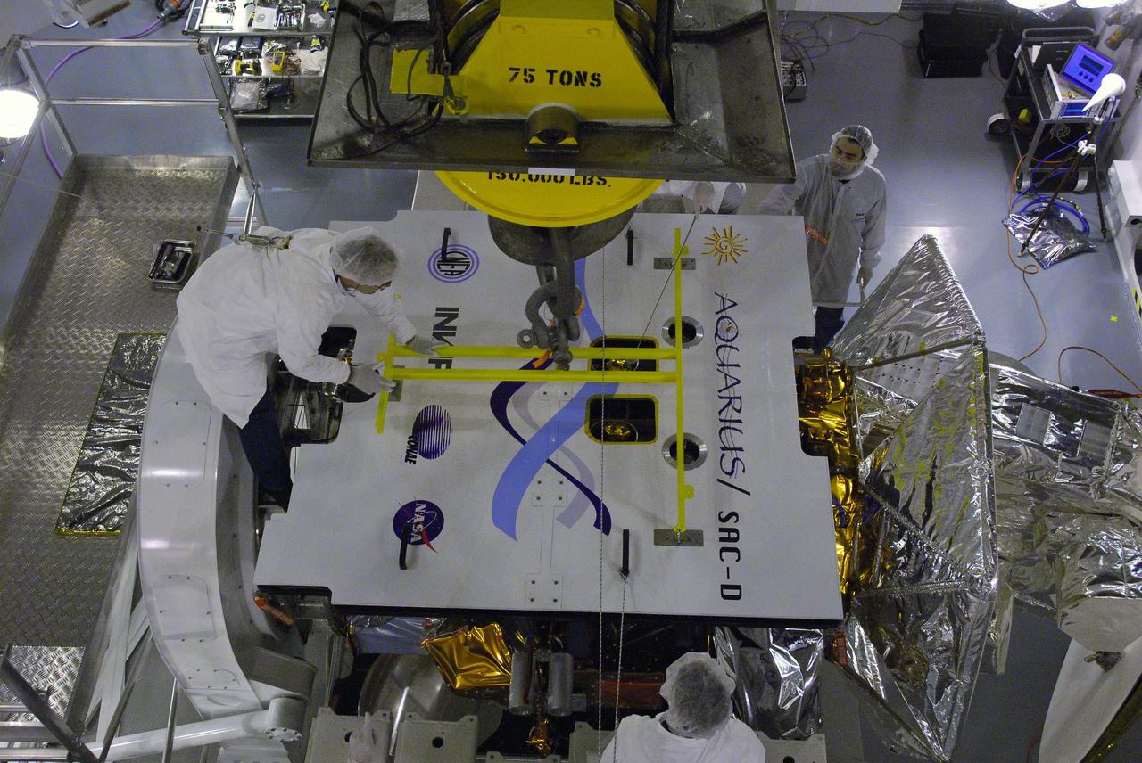 VANDENBERG AIR FORCE BASE, Calif. -- In Space Systems International's Payload Processing Facility at Vandenberg Air Force Base in California, technicians detach the overhead crane that moved the second solar array for integration and testing to the Aquarius/SAC-D spacecraft.  Following final tests, the spacecraft will be integrated to a United Launch Alliance Delta II rocket in preparation for the targeted June launch. Aquarius, the NASA-built primary instrument on the SAC-D spacecraft, will provide new insights into how variations in ocean surface salinity relate to fundamental climate processes on its three-year mission. Photo credit: NASA/VAFB