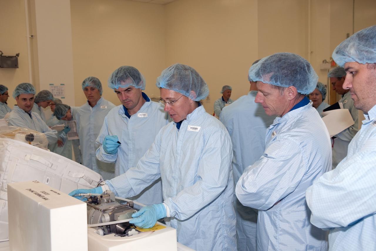 CAPE CANAVERAL, Fla. -- Space shuttle Atlantis' STS-135 crew participates in a crew equipment interface test, or CEIT, in the Space Station Processing Facility at NASA's Kennedy Space Center in Florida. The purpose of CEIT is for flight crew members to become familiar with the hardware and tools they will work with in space. Mission Specialist Sandy Magnus performs some hands-on tasks while Mission Specialist Rex Walheim, left, Commander Chris Ferguson, right, and technicians observe. STS-135 will carry the Raffaello multi-purpose logistics module packed with supplies, logistics and spare parts to the International Space Station. STS-135 also will return a failed ammonia pump module on the Lightweight Multi-Purpose Experiment Support Structure Carrier, or LMC, to help NASA better understand the failure mechanism and improve pump designs for future systems.          STS-135, targeted to launch June 28, will be the 33rd flight of Atlantis, the 37th shuttle mission to the space station, and the 135th and final mission of NASA's Space Shuttle Program. For more information visit, www.nasa.gov/mission_pages/shuttle/shuttlemissions/sts135/index.html. Photo credit: NASA/Jim Grossmann