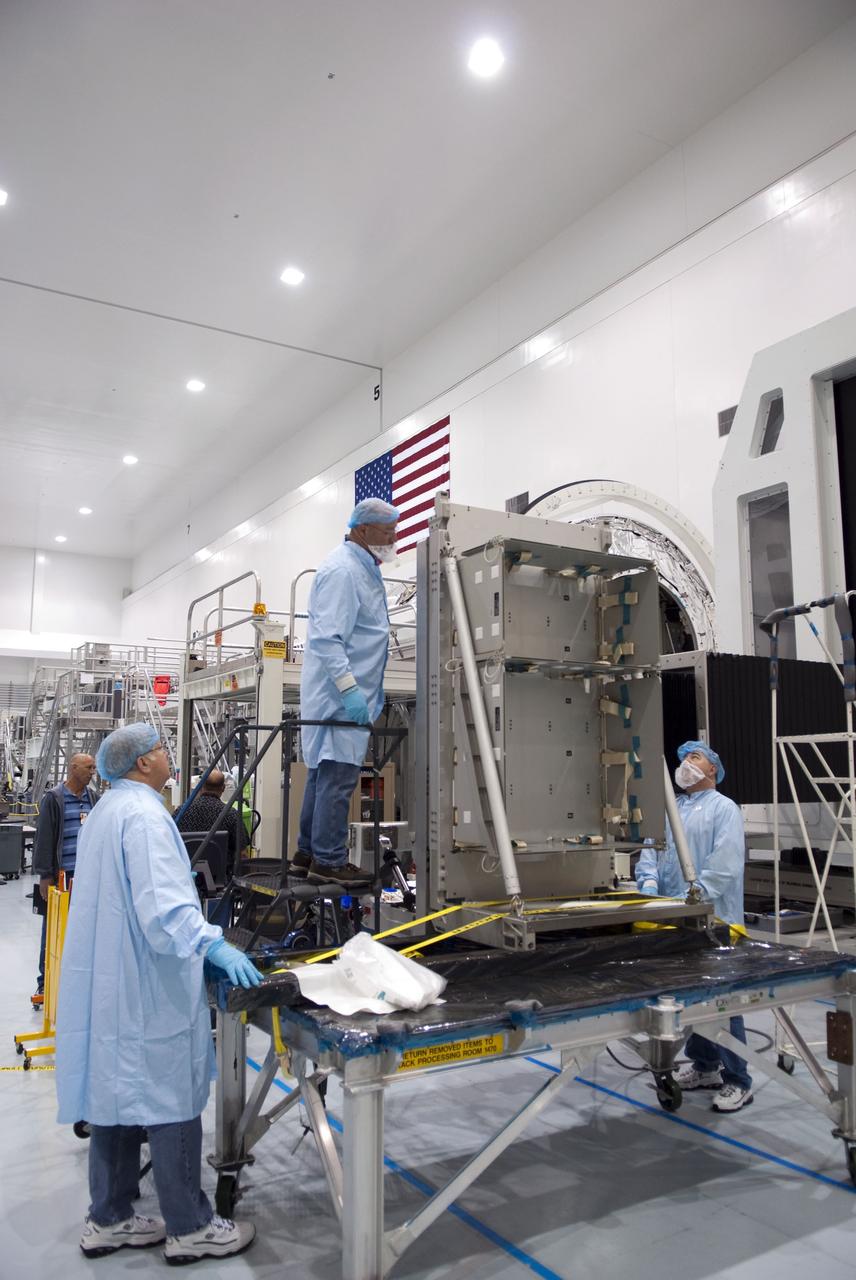 CAPE CANAVERAL, Fla. -- In the Space Station Processing Facility at NASA's Kennedy Space Center in Florida, technicians prepare to load cargo onto a resupply stowage platform. The platform will be installed inside the Raffaello multi-purpose logistics module, in the background, for space shuttle Atlantis' flight to the International Space Station.     Atlantis and its payload are being prepared for the STS-135 mission, which will deliver Raffaello packed with supplies and spare parts to the station. STS-135, targeted to launch June 28, will be the 33rd flight of Atlantis, the 37th shuttle mission to the space station, and the 135th and final mission of NASA's Space Shuttle Program. For more information, visit www.nasa.gov/mission_pages/shuttle/shuttlemissions/sts135/index.html. Photo credit: NASA/Jim Grossmann