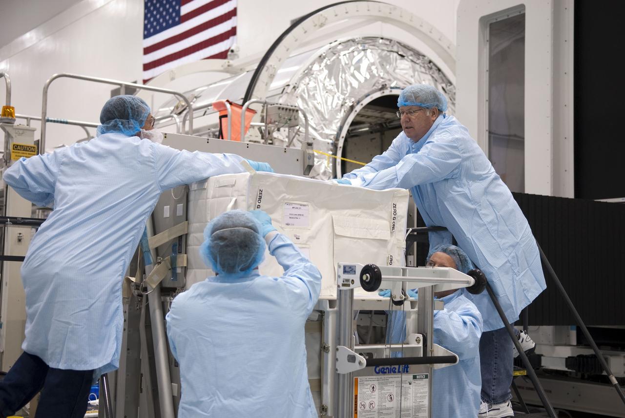 CAPE CANAVERAL, Fla. -- In the Space Station Processing Facility at NASA's Kennedy Space Center in Florida, technicians load a cargo bag onto a resupply stowage platform. The platform and its cargo will be installed inside the Raffaello multi-purpose logistics module, in the background, for space shuttle Atlantis' flight to the International Space Station.    Atlantis and its payload are being prepared for the STS-135 mission, which will deliver Raffaello packed with supplies and spare parts to the station. STS-135, targeted to launch June 28, will be the 33rd flight of Atlantis, the 37th shuttle mission to the space station, and the 135th and final mission of NASA's Space Shuttle Program. For more information, visit www.nasa.gov/mission_pages/shuttle/shuttlemissions/sts135/index.html. Photo credit: NASA/Jim Grossmann
