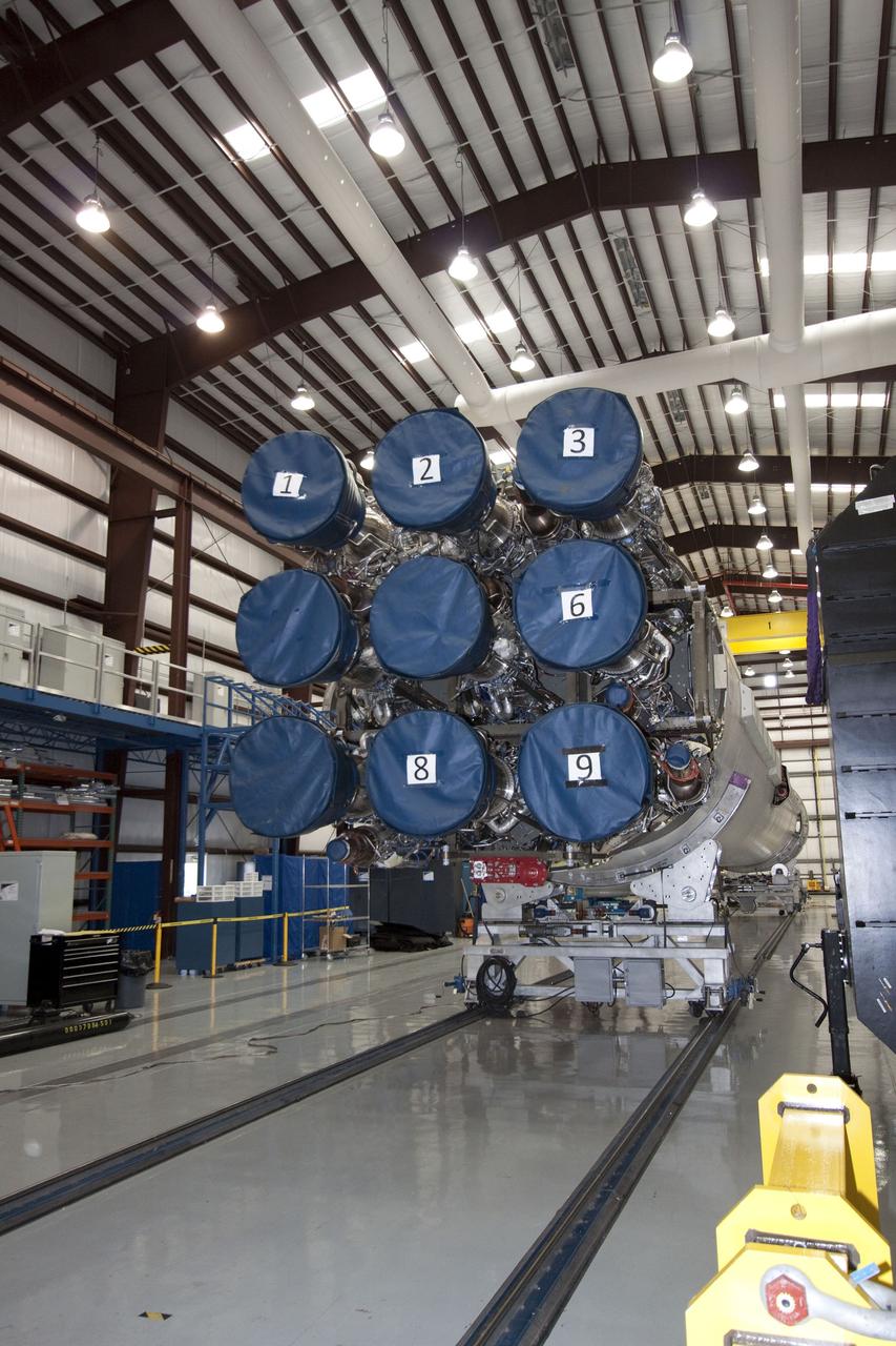 CAPE CANAVERAL, Fla. -- The first stage of a Falcon 9 built by Space Exploration Technologies (SpaceX) sits on processing stands inside the company's hangar at Launch Complex 40 at Cape Canaveral Air Force Station in Florida. This image shows the nine Merlin engines that power the first stage. Technicians are preparing the rocket for the second launch in the Commercial Orbital Transportation Services, or COTS, program to demonstrate private companies' ability to launch uncrewed spacecraft into orbit. A follow-on contract, Commercial Resupply Services, calls for SpaceX to launch 12 resupply missions to the International Space Station between 2011 and 2015. Photo credit: NASA/Jack Pfaller