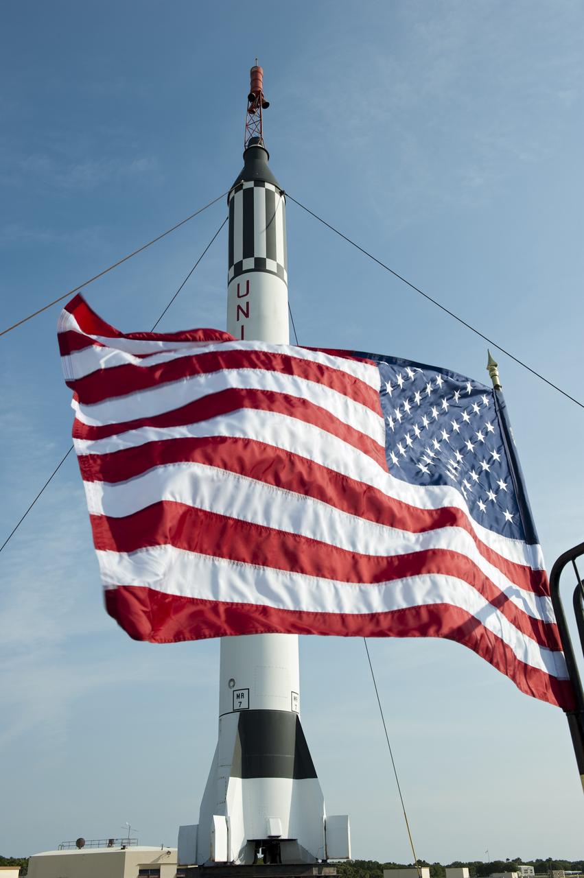 CAPE CANAVERAL, Fla. -- The U.S. flag waves proudly in front of a replica of a Mercury-Redstone rocket at Complex 5/6 on Cape Canaveral Air Force Station in Florida.    A celebration was held at the launch site of the first U.S. manned spaceflight May 5, 1961, to mark the 50th anniversary of the flight.  Fifty years ago, astronaut Alan Shepard lifted off inside the Mercury capsule, "Freedom 7," atop an 82-foot-tall Mercury-Redstone rocket at 9:34 a.m. EST, sending him on a remarkably successful, 15-minute suborbital flight. The event was attended by more than 200 workers from the original Mercury program and included a re-creation of Shepard's flight and recovery, as well as a tribute to his contributions as a moonwalker on the Apollo 14 lunar mission. For more information, visit www.nasa.gov/topics/history/milestones/index.html. Photo credit: NASA/Kim Shiflett