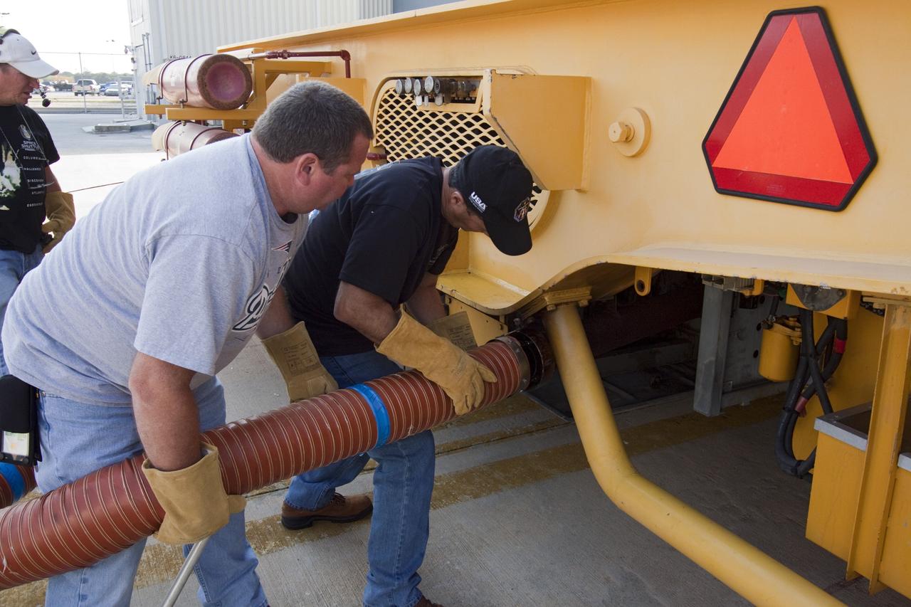 CAPE CANAVERAL, Fla. -- Workers attach an exhaust hose to the Orbiter Transporter System (OTS) at Orbiter Processing Facility-1 at NASA's Kennedy Space Center in Florida. The OTS is being moved under shuttle Atlantis for its rollover to the nearby Vehicle Assembly Building (VAB).    Once inside the VAB, Atlantis will be joined to its solid rocket boosters and external fuel tank on the mobile launcher platform. Later this month, Atlantis is scheduled to "rollout" to Launch Pad 39A on the STS-135 mission, which will deliver the Raffaello multi-purpose logistics module packed with supplies and spare parts to the International Space Station. STS-135, targeted to launch June 28, will be the 33rd flight of Atlantis, the 37th shuttle mission to the station, and the 135th and final mission of NASA's Space Shuttle Program. For more information, visit www.nasa.gov/mission_pages/shuttle/shuttlemissions/sts135/index.html. NASA/Jack Pfaller