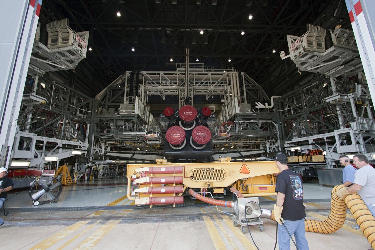 CAPE CANAVERAL, Fla. -- In Orbiter Processing Facility-1 at NASA's Kennedy Space Center in Florida, workers guide the Orbiter Transporter System (OTS) under shuttle Atlantis for its move, or rollover, to the nearby Vehicle Assembly Building (VAB).      Once inside the VAB, Atlantis will be joined to its solid rocket boosters and external fuel tank on the mobile launcher platform. Later this month, Atlantis is scheduled to "rollout" to Launch Pad 39A on the STS-135 mission, which will deliver the Raffaello multi-purpose logistics module packed with supplies and spare parts to the International Space Station. STS-135, targeted to launch June 28, will be the 33rd flight of Atlantis, the 37th shuttle mission to the station, and the 135th and final mission of NASA's Space Shuttle Program. For more information, visit www.nasa.gov/mission_pages/shuttle/shuttlemissions/sts135/index.html. NASA/Jack Pfaller