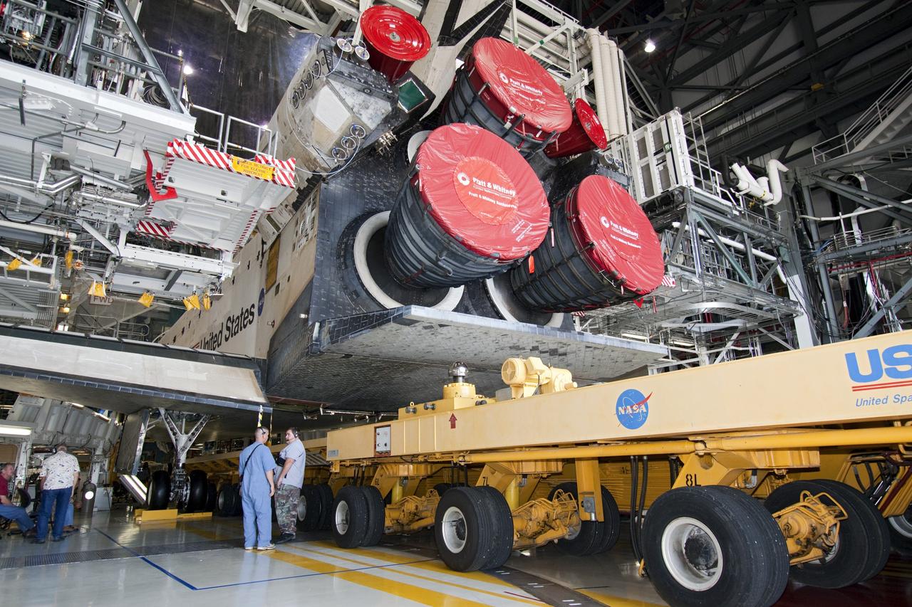 CAPE CANAVERAL, Fla. -- In Orbiter Processing Facility-1 at NASA's Kennedy Space Center in Florida, workers guide the Orbiter Transporter System (OTS) under shuttle Atlantis for its move, or rollover, to the nearby Vehicle Assembly Building (VAB).      Once inside the VAB, Atlantis will be joined to its solid rocket boosters and external fuel tank on the mobile launcher platform. Later this month, Atlantis is scheduled to "rollout" to Launch Pad 39A on the STS-135 mission, which will deliver the Raffaello multi-purpose logistics module packed with supplies and spare parts to the International Space Station. STS-135, targeted to launch June 28, will be the 33rd flight of Atlantis, the 37th shuttle mission to the station, and the 135th and final mission of NASA's Space Shuttle Program. For more information, visit www.nasa.gov/mission_pages/shuttle/shuttlemissions/sts135/index.html. NASA/Jack Pfaller