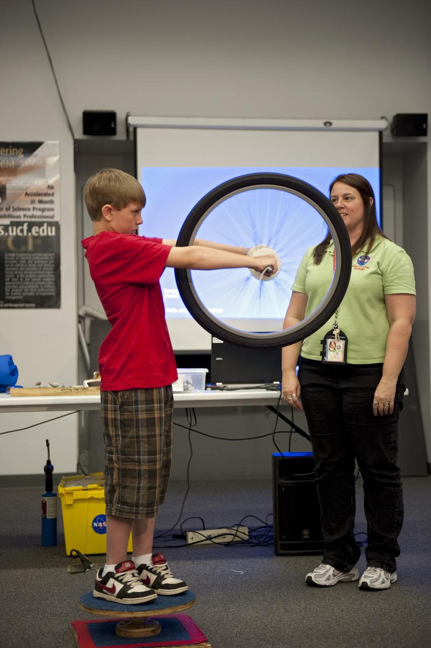 Cape Canaveral, Fla. -- Students from across the nation gathered at NASA's Kennedy Space Center in Florida for the NASA Explorer Schools (NES) symposium. In the Center for Space Education at Kennedy, a student participates in a hands-on activity as an education specialist looks on.         During the NES event, students presented their investigation project to their peers, scientists, engineers and education specialists. About 60 fourth- through 12-grade students nationwide are at the center May 4-7 participating in tours of processing and launch facilities and the U.S. Astronaut Hall of Fame, as well as several educational activities and a career panel question-and-answer session. About 30 teachers will receive professional development opportunities during the symposium. The participants were competitively selected after they completed an original investigation focused on existing NASA missions or research interests. Photo Credit: NASA/Kim Shiflett