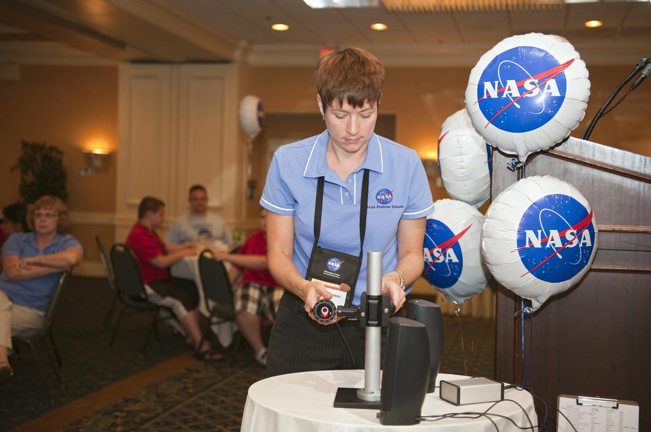 Cape Canaveral, Fla. -- Rachael Power, education specialist sets up a display for fourth- through 12-grade students and their teachers from across the nation during closing events at the NASA Explorer Schools Symposium in Florida.              During the NES gathering, students presented their investigation project to their peers, scientists, engineers and education specialists. About 60 fourth- through 12-grade students nationwide are at the center May 4-7 participating in tours of processing and launch facilities and the U.S. Astronaut Hall of Fame, as well as several educational activities and a career panel question-and-answer session. About 30 teachers will receive professional development opportunities during the symposium. The participants were competitively selected after they completed an original investigation focused on existing NASA missions or research interests. Photo Credit: NASA/Kim Shiflett