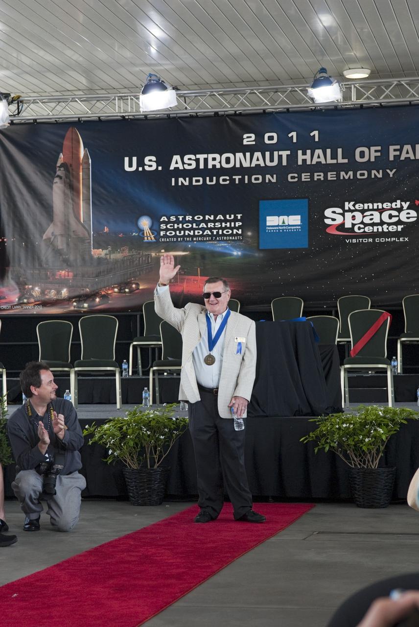 Cape Canaveral, Fla. -- Hall of Fame astronaut Dick Gordon thanks the audience for their applause at the 2011 U.S. Astronaut Hall of Fame induction ceremony at NASA's Kennedy Space Center Visitor Complex in Florida.          Hall of Fame astronauts and visitors gathered to honor 2011 inductees Karol "Bo" Bobko and Susan Helms. During his 19 years in the astronaut program, Bobko flew on three space shuttle missions and logged more than 386 hours in space. He served as pilot during the first voyage of space shuttle Challenger aboard STS-6 in April 1983 and as commander during the maiden flight of space shuttle Atlantis aboard STS-51J in October 1985. Helms, a five-time space shuttle astronaut, has logged 5,064 hours in space. During her stay onboard the International Space Station as a member of the Expedition-2 crew in 2001, Helms performed a world record 8 hour and 56 minute spacewalk. Bobko and Helms join the ranks of the U.S. Astronaut Hall of Fame bringing the number of space explorers enshrined in the Hall of Fame to 79. Photo Credit: NASA/Jim Grossmann