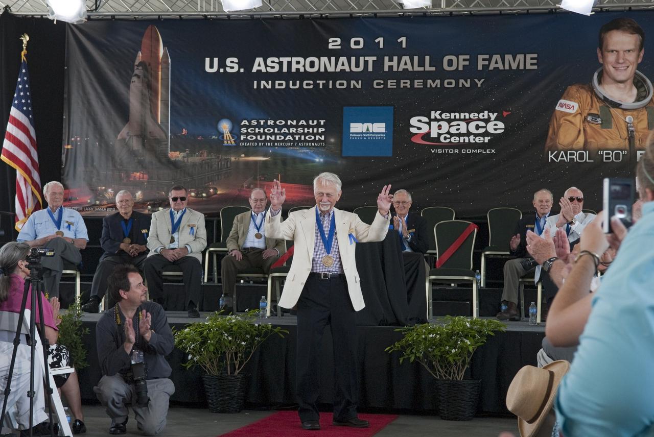 Cape Canaveral, Fla. -- Hall of Fame astronaut Owen Garriott thanks the audience for their applause at the 2011 U.S. Astronaut Hall of Fame induction ceremony at NASA's Kennedy Space Center Visitor Complex in Florida.        Hall of Fame astronauts and visitors gathered to honor 2011 inductees Karol "Bo" Bobko and Susan Helms. During his 19 years in the astronaut program, Bobko flew on three space shuttle missions and logged more than 386 hours in space. He served as pilot during the first voyage of space shuttle Challenger aboard STS-6 in April 1983 and as commander during the maiden flight of space shuttle Atlantis aboard STS-51J in October 1985. Helms, a five-time space shuttle astronaut, has logged 5,064 hours in space. During her stay onboard the International Space Station as a member of the Expedition-2 crew in 2001, Helms performed a world record 8 hour and 56 minute spacewalk. Bobko and Helms join the ranks of the U.S. Astronaut Hall of Fame bringing the number of space explorers enshrined in the Hall of Fame to 79. Photo Credit: NASA/Jim Grossmann