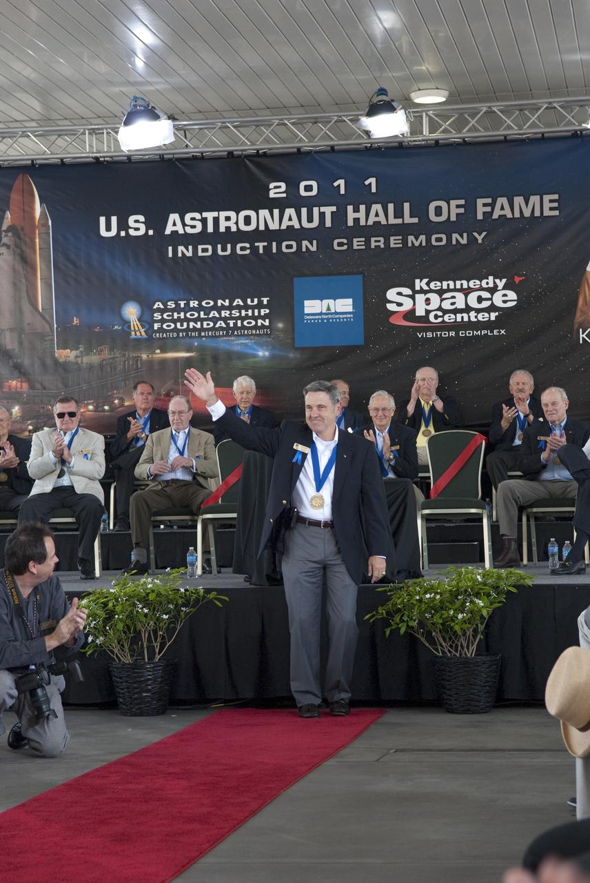 Cape Canaveral, Fla. -- Hall of Fame astronaut and present Kennedy Center Director Bob Cabana is warmly greeted as he is introduced as a previous inductee into the U.S. Astronaut Hall of Fame at the 2011 U.S. Astronaut Hall of Fame induction ceremony at NASA's Kennedy Space Center Visitor Complex in Florida.        Hall of Fame astronauts and visitors gathered to honor 2011 inductees Karol "Bo" Bobko and Susan Helms. During his 19 years in the astronaut program, Bobko flew on three space shuttle missions and logged more than 386 hours in space. He served as pilot during the first voyage of space shuttle Challenger aboard STS-6 in April 1983 and as commander during the maiden flight of space shuttle Atlantis aboard STS-51J in October 1985. Helms, a five-time space shuttle astronaut, has logged 5,064 hours in space. During her stay onboard the International Space Station as a member of the Expedition-2 crew in 2001, Helms performed a world record 8 hour and 56 minute spacewalk. Bobko and Helms join the ranks of the U.S. Astronaut Hall of Fame bringing the number of space explorers enshrined in the Hall of Fame to 79. Photo Credit: NASA/Jim Grossmann
