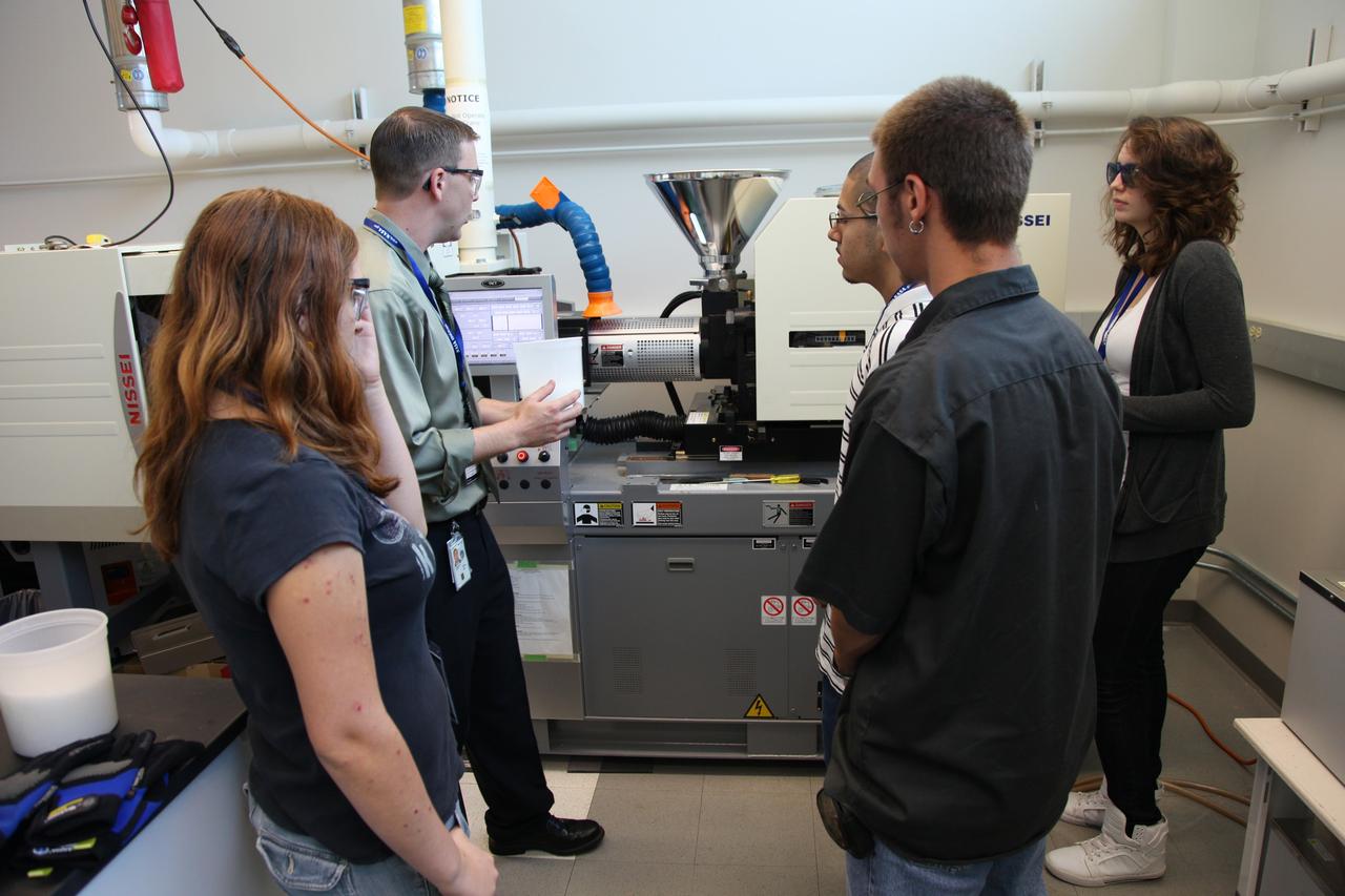 Cape Canaveral, Fla. -- Students listen intently as a laboratory technician describes the experiment being conducted in Kennedy’s Space Life Sciences Laboratory (SLSL). High-school students from two Orlando, Fla., schools travelled to NASA’s Kennedy Space Center in Florida to participate in National Lab Day activities. During the event, about 80 students, toured various facilities and engaged in educational hands-on activities. National Lab Day is a partnership between federal agencies, foundations, professional societies and organizations devoted to promoting science, technology, engineering and math, or STEM, hands-on discovery-based laboratory experiences for students. Photo Credit: NASA/Frankie Martin