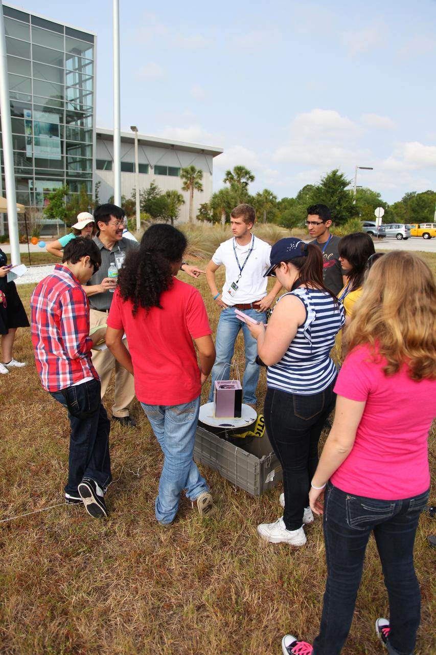 Cape Canaveral, Fla. -- Students listen intently as a laboratory technician describes the high-altitude balloon experiment that's being conducted on the grounds of Kennedy’s Space Life Sciences Laboratory (SLSL). High-school students from two Orlando, Fla., schools travelled to NASA’s Kennedy Space Center in Florida to participate in National Lab Day activities. During the event, about 80 students, toured various facilities and engaged in educational hands-on activities. National Lab Day is a partnership between federal agencies, foundations, professional societies and organizations devoted to promoting science, technology, engineering and math, or STEM, hands-on discovery-based laboratory experiences for students. Photo Credit: NASA/Frankie Martin
