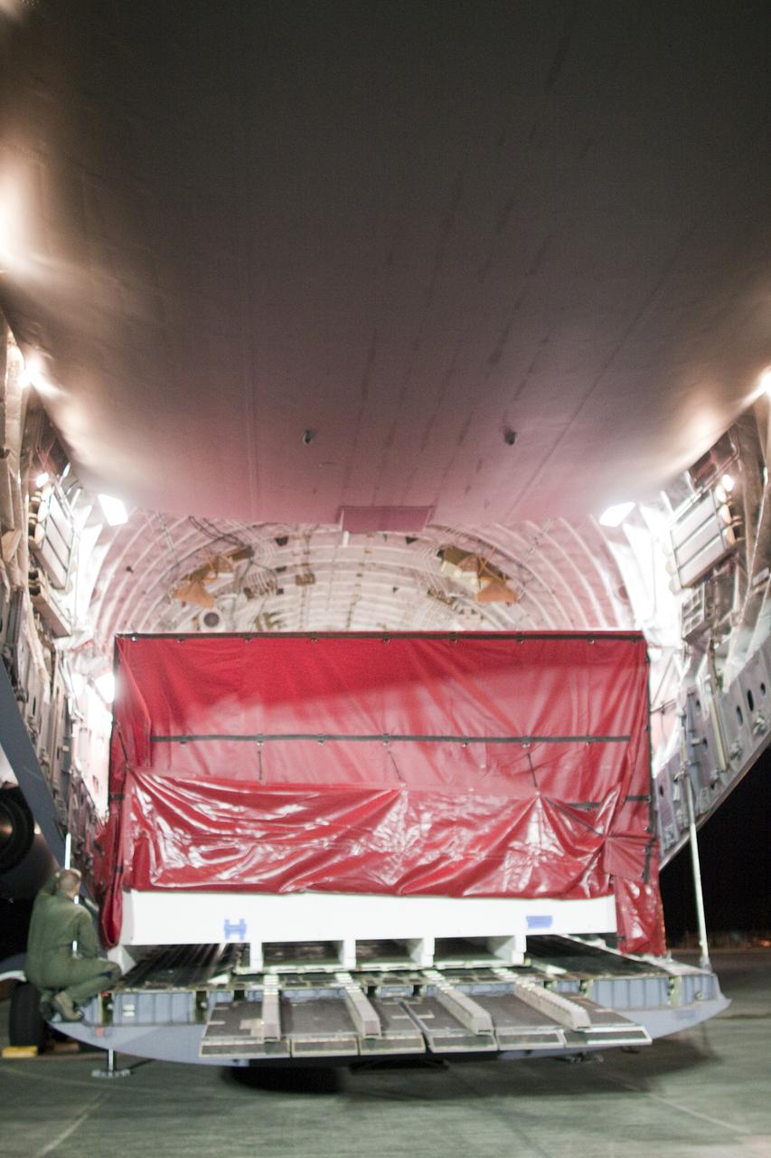 CAPE CANAVERAL, Fla. -- Workers begin to unload a container holding the heat shield, one of the first three elements for NASA's Mars Science Laboratory (MSL) that arrived at NASA Kennedy Space Center's Shuttle Landing Facility aboard an Air Force C-17 cargo plane.       The cruise stage, back shell and heat shield, the first flight elements to arrive for the MSL mission, were taken to the Payload Hazardous Servicing Facility (PHSF) located in the KSC Industrial Area to begin processing. The Curiosity rover will arrive next month.    A United Launch Alliance Atlas V-541 configuration will be used to loft MSL into space. Curiosity’s 10 science instruments are designed to search for evidence on whether Mars has had environments favorable to microbial life, including chemical ingredients for life.  The unique rover will use a laser to look inside rocks and release its gasses so that the rover’s spectrometer can analyze and send the data back to Earth. MSL is scheduled to launch from Cape Canaveral Air Force Station in Florida Nov. 25 with a window extending to Dec. 18 and arrival at Mars Aug. 2012. For more information, visit http://www.nasa.gov/msl. Photo credit: NASA/Troy Cryder