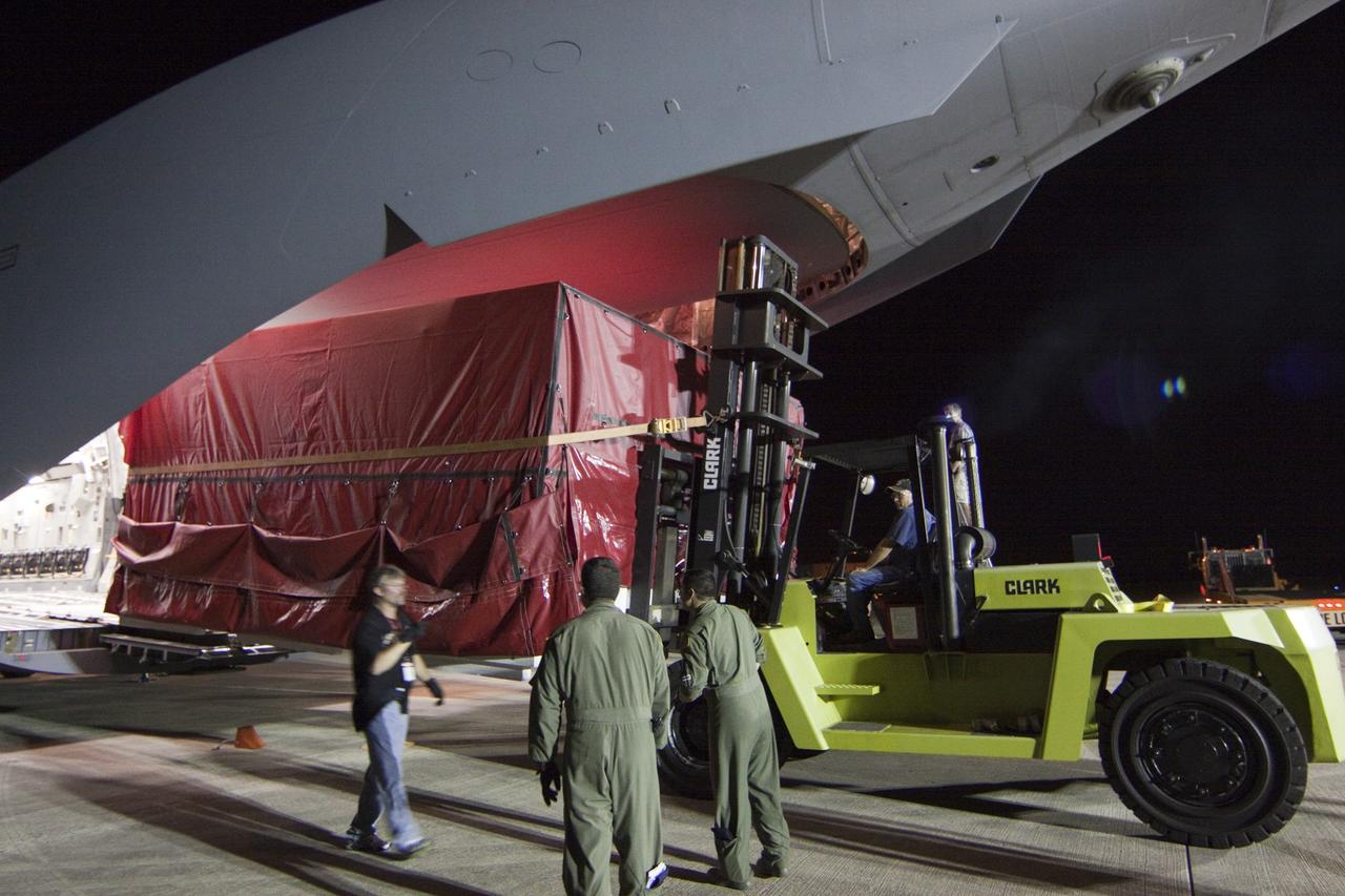 CAPE CANAVERAL, Fla. -- Workers unload a container holding the heat shield, one of the first three elements for NASA's Mars Science Laboratory (MSL) that arrived at NASA Kennedy Space Center's Shuttle Landing Facility aboard an Air Force C-17 cargo plane.       The cruise stage, back shell and heat shield, the first flight elements to arrive for the MSL mission, were taken to the Payload Hazardous Servicing Facility (PHSF) located in the KSC Industrial Area to begin processing. The Curiosity rover will arrive next month.     A United Launch Alliance Atlas V-541 configuration will be used to loft MSL into space. Curiosity’s 10 science instruments are designed to search for evidence on whether Mars has had environments favorable to microbial life, including chemical ingredients for life.  The unique rover will use a laser to look inside rocks and release its gasses so that the rover’s spectrometer can analyze and send the data back to Earth. MSL is scheduled to launch from Cape Canaveral Air Force Station in Florida Nov. 25 with a window extending to Dec. 18 and arrival at Mars Aug. 2012. For more information, visit http://www.nasa.gov/msl. Photo credit: NASA/Troy Cryder