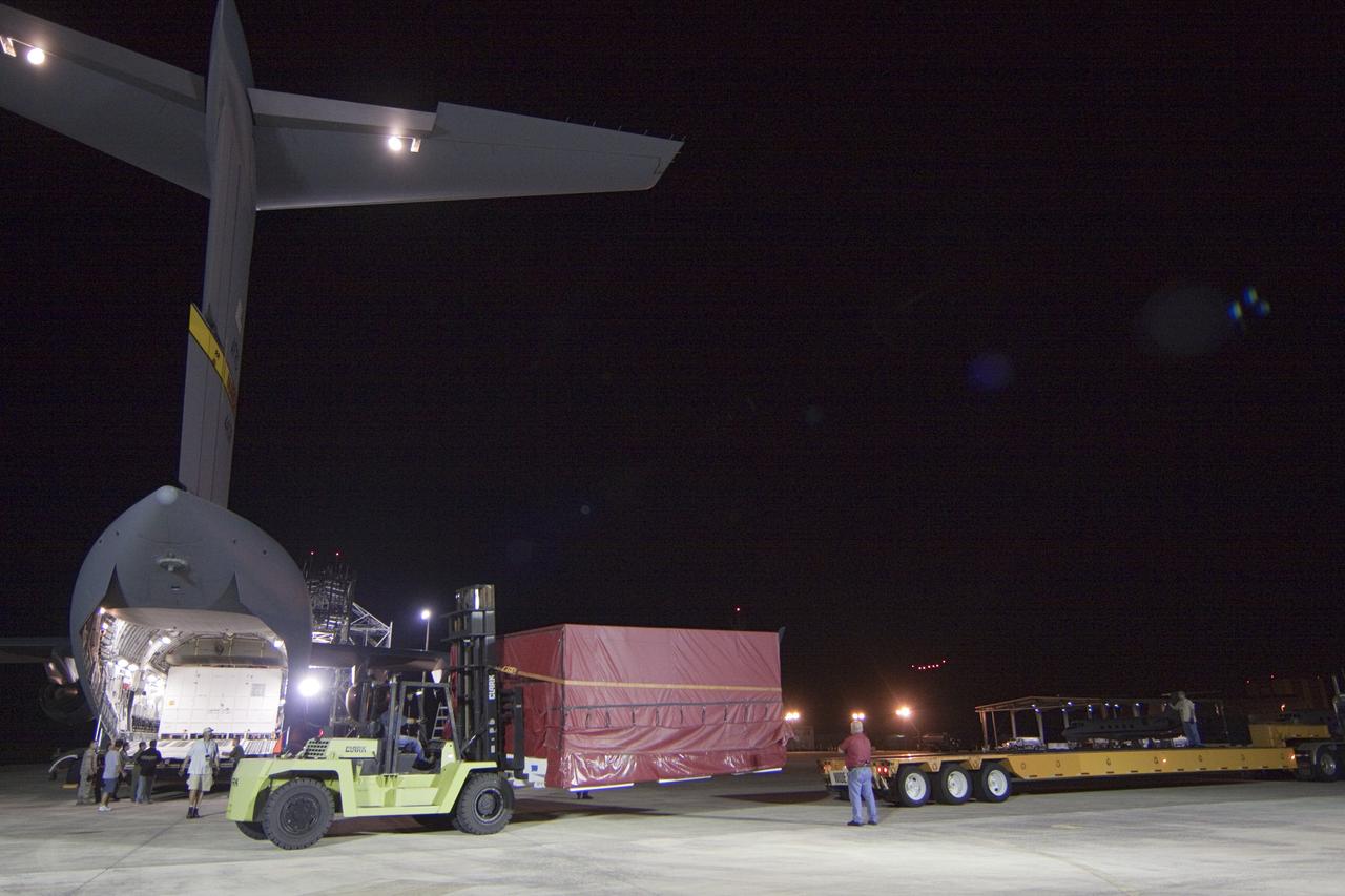 CAPE CANAVERAL, Fla. -- Workers load onto a transporter a container holding the heat shield, one of the first three elements for NASA's Mars Science Laboratory (MSL), that arrived at NASA Kennedy Space Center's Shuttle Landing Facility.        The cruise stage, back shell and heat shield, the first flight elements to arrive for the MSL mission, were taken to the Payload Hazardous Servicing Facility (PHSF) located in the KSC Industrial Area to begin processing. The Curiosity rover will arrive next month.    A United Launch Alliance Atlas V-541 configuration will be used to loft MSL into space. Curiosity’s 10 science instruments are designed to search for evidence on whether Mars has had environments favorable to microbial life, including chemical ingredients for life.  The unique rover will use a laser to look inside rocks and release its gasses so that the rover’s spectrometer can analyze and send the data back to Earth. MSL is scheduled to launch from Cape Canaveral Air Force Station in Florida Nov. 25 with a window extending to Dec. 18 and arrival at Mars Aug. 2012. For more information, visit http://www.nasa.gov/msl. Photo credit: NASA/Troy Cryder