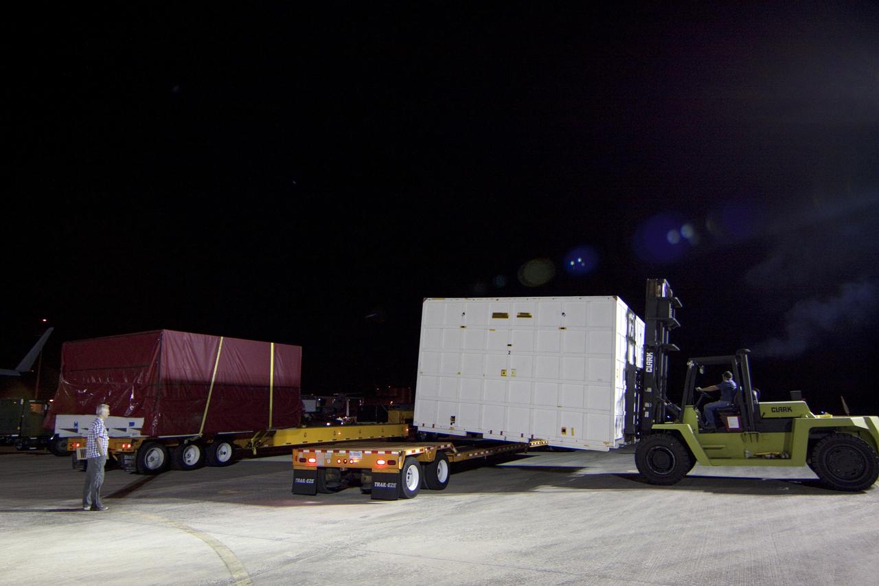 CAPE CANAVERAL, Fla. -- Workers load onto a transporter a container holding the back shell, one of the first three elements for NASA's Mars Science Laboratory (MSL), that arrived at NASA Kennedy Space Center's Shuttle Landing Facility.       The cruise stage, back shell and heat shield, the first flight elements to arrive for the MSL mission, were taken to the Payload Hazardous Servicing Facility (PHSF) located in the KSC Industrial Area to begin processing. The Curiosity rover will arrive next month.    A United Launch Alliance Atlas V-541 configuration will be used to loft MSL into space. Curiosity’s 10 science instruments are designed to search for evidence on whether Mars has had environments favorable to microbial life, including chemical ingredients for life.  The unique rover will use a laser to look inside rocks and release its gasses so that the rover’s spectrometer can analyze and send the data back to Earth. MSL is scheduled to launch from Cape Canaveral Air Force Station in Florida Nov. 25 with a window extending to Dec. 18 and arrival at Mars Aug. 2012. For more information, visit http://www.nasa.gov/msl. Photo credit: NASA/Troy Cryder