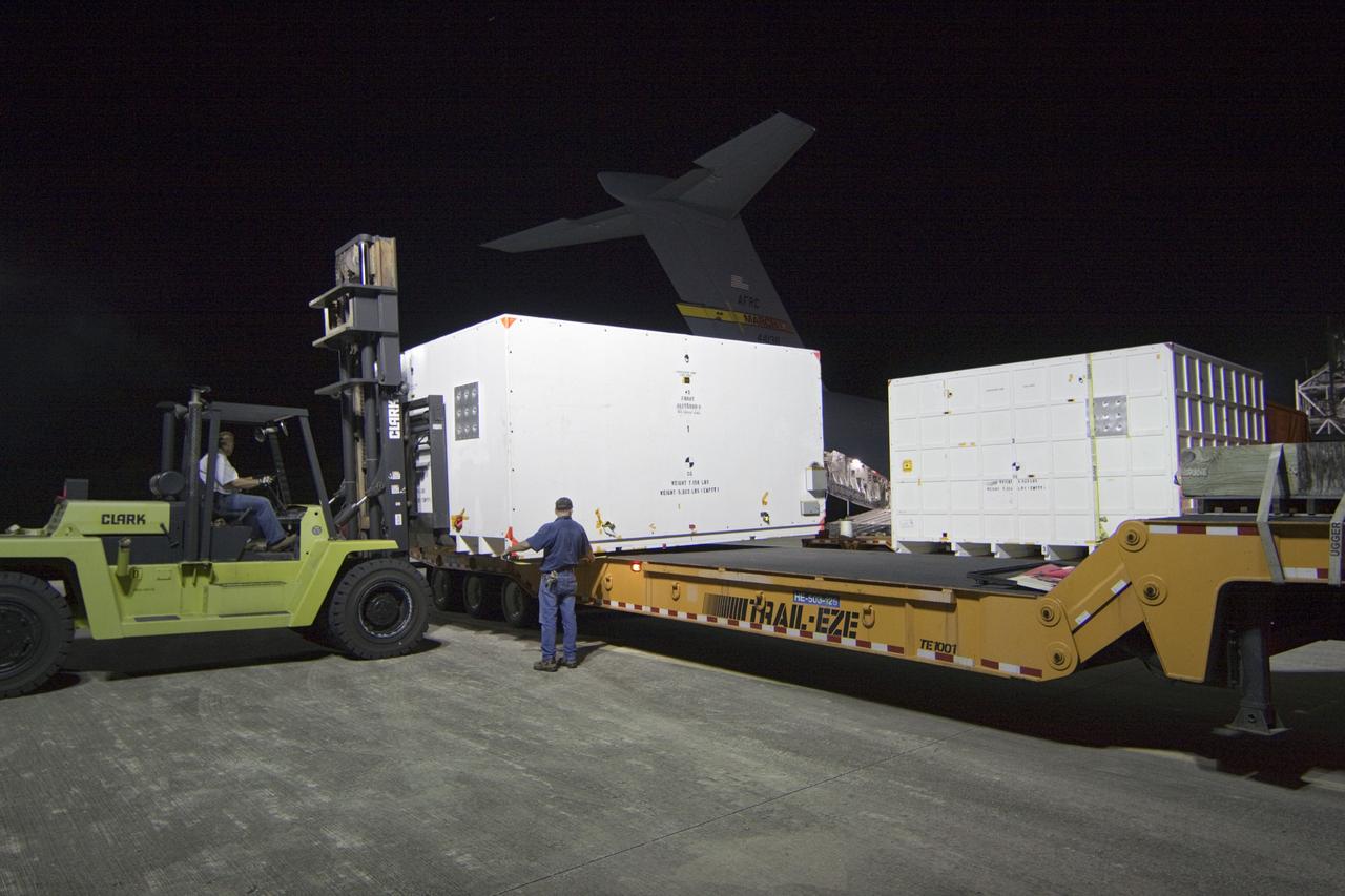 CAPE CANAVERAL, Fla. -- Workers load onto a transporter a container holding the cruise stage, one of the first three elements for NASA's Mars Science Laboratory (MSL) that arrived at NASA Kennedy Space Center's Shuttle Landing Facility aboard an Air Force C-17 cargo plane.        The cruise stage, back shell and heat shield, the first flight elements to arrive for the MSL mission, were taken to the Payload Hazardous Servicing Facility (PHSF) located in the KSC Industrial Area to begin processing. The Curiosity rover will arrive next month.     A United Launch Alliance Atlas V-541 configuration will be used to loft MSL into space. Curiosity’s 10 science instruments are designed to search for evidence on whether Mars has had environments favorable to microbial life, including chemical ingredients for life.  The unique rover will use a laser to look inside rocks and release its gasses so that the rover’s spectrometer can analyze and send the data back to Earth. MSL is scheduled to launch from Cape Canaveral Air Force Station in Florida Nov. 25 with a window extending to Dec. 18 and arrival at Mars Aug. 2012. For more information, visit http://www.nasa.gov/msl. Photo credit: NASA/Troy Cryder