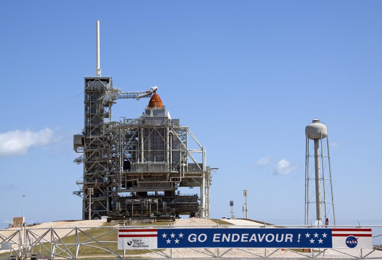 CAPE CANAVERAL, Fla. - A "Go Endeavour" banner adorns the perimeter gate on Launch Pad 39A at NASA's Kennedy Space Center in Florida. The rotating service structure (RSS), which has been providing weather protection and access to space shuttle Endeavour while it awaits lift off on the pad, soon will move away in preparation for launch. RSS "rollback," as it's called, began at 11:44 a.m. EDT on May 15 and was completed at 12:24 p.m.               STS-134 will deliver the Alpha Magnetic Spectrometer-2 (AMS), Express Logistics Carrier-3, a high-pressure gas tank and additional spare parts for the Dextre robotic helper to the International Space Station. May 16 at 8:56 a.m. will be the second launch attempt for Endeavour. The first attempt on April 29 was scrubbed because of an issue associated with a faulty power distribution box called the aft load control assembly-2 (ALCA-2). STS-134 will be the final spaceflight for Endeavour. For more information visit, www.nasa.gov/mission_pages/shuttle/shuttlemissions/sts134/index.html. Photo credit: NASA/Jack Pfaller