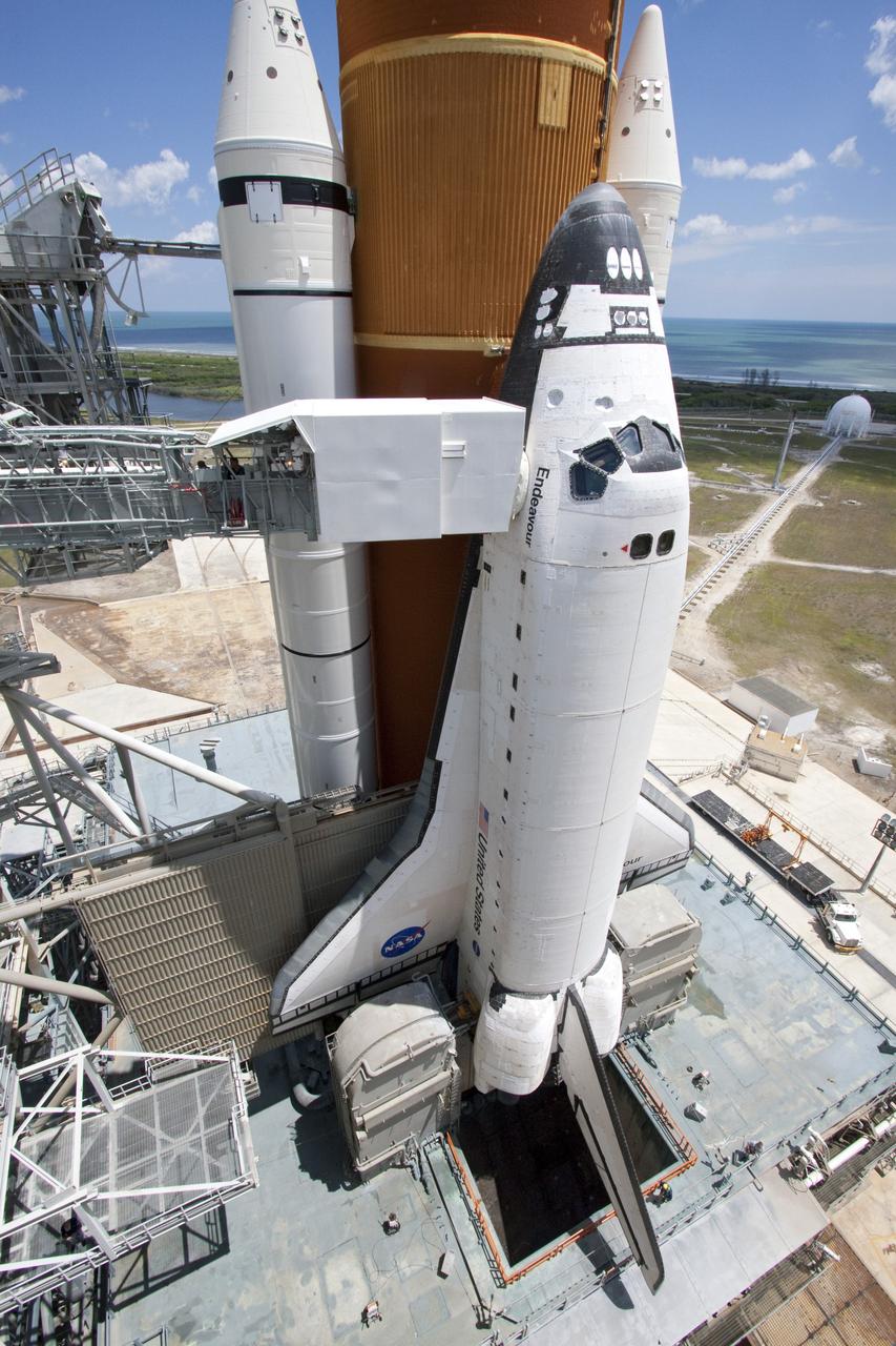 CAPE CANAVERAL, Fla. - Backdropped by a beautiful blue sky and the crystal-clear Atlantic Ocean, space shuttle Endeavour is revealed on Launch Pad 39A at NASA's Kennedy Space Center in Florida as the rotating service structure (RSS) moves away. The structure provides weather protection and access to the shuttle while it awaits lift off on the pad. RSS "rollback," as it's called, began at 11:44 a.m. EDT on May 15 and was completed at 12:24 p.m.   STS-134 will deliver the Alpha Magnetic Spectrometer-2 (AMS), Express Logistics Carrier-3, a high-pressure gas tank and additional spare parts for the Dextre robotic helper to the International Space Station. May 16 at 8:56 a.m. will be the second launch attempt for Endeavour. The first attempt on April 29 was scrubbed because of an issue associated with a faulty power distribution box called the aft load control assembly-2 (ALCA-2). STS-134 will be the final spaceflight for Endeavour. For more information visit, www.nasa.gov/mission_pages/shuttle/shuttlemissions/sts134/index.html. Photo credit: NASA/Jack Pfaller