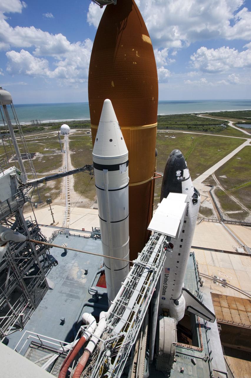 CAPE CANAVERAL, Fla. - Backdropped by a beautiful blue sky and the crystal-clear Atlantic Ocean, space shuttle Endeavour is revealed on Launch Pad 39A at NASA's Kennedy Space Center in Florida as the rotating service structure (RSS) moves away. The structure provides weather protection and access to the shuttle while it awaits lift off on the pad. RSS "rollback," as it's called, began at 11:44 a.m. EDT on May 15 and was completed at 12:24 p.m.       STS-134 will deliver the Alpha Magnetic Spectrometer-2 (AMS), Express Logistics Carrier-3, a high-pressure gas tank and additional spare parts for the Dextre robotic helper to the International Space Station. May 16 at 8:56 a.m. will be the second launch attempt for Endeavour. The first attempt on April 29 was scrubbed because of an issue associated with a faulty power distribution box called the aft load control assembly-2 (ALCA-2). STS-134 will be the final spaceflight for Endeavour. For more information visit, www.nasa.gov/mission_pages/shuttle/shuttlemissions/sts134/index.html. Photo credit: NASA/Jack Pfaller