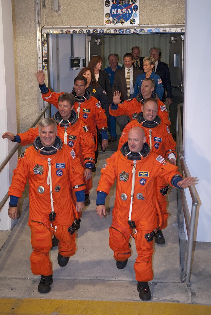 CAPE CANAVERAL, Fla. -- Space shuttle Endeavour's six STS-134 astronauts, dressed in their orange launch-and-entry suits, wave to news media and other spectators as they walk toward the Astrovan parked in front of the Operations and Checkout Building at NASA's Kennedy Space Center in Florida. The modified Airstream recreational vehicle, which has transported astronauts to their spacecraft since 1984, will take the crew to Launch Pad 39A. Leading the way are Pilot Greg H. Johnson, front left, and Commander Mark Kelly, front right. Behind Johnson are Mission Specialists Roberto Vittori with the European Space Agency and Greg Chamitoff. Behind Kelly are Mission Specialists Michael Fincke and Andrew Feustel.          STS-134 will deliver the Alpha Magnetic Spectrometer-2 (AMS), Express Logistics Carrier-3, a high-pressure gas tank and additional spare parts for the Dextre robotic helper to the International Space Station. May 16 at 8:56 a.m. will be the second launch attempt for Endeavour. The first attempt on April 29 was scrubbed because of an issue associated with a faulty power distribution box called the aft load control assembly-2 (ALCA-2). STS-134 will be the final spaceflight for Endeavour. For more information visit, www.nasa.gov/mission_pages/shuttle/shuttlemissions/sts134/index.html. Photo credit: NASA/Kim Shiflett