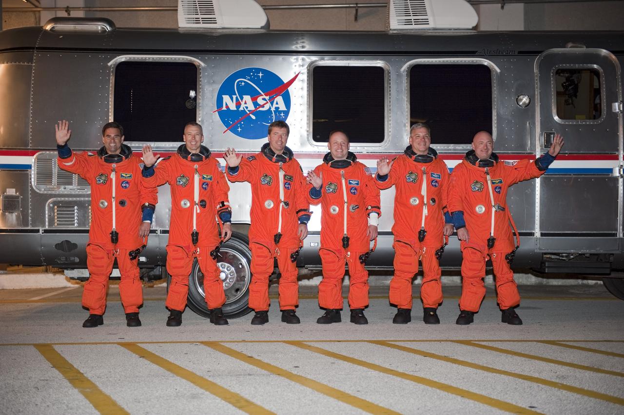 CAPE CANAVERAL, Fla. -- Space shuttle Endeavour's six STS-134 astronauts, dressed in their orange launch-and-entry suits, wave to news media and other spectators in front of the Astrovan parked in front of the Operations and Checkout Building at NASA's Kennedy Space Center in Florida. The modified Airstream recreational vehicle, which has transported astronauts to their spacecraft since 1984, will take the crew to Launch Pad 39A. From left, are Mission Specialists Greg Chamitoff, Andrew Feustel, Roberto Vittori with the European Space Agency and Michael Fincke, Pilot Greg H. Johnson, and Commander Mark Kelly.        STS-134 will deliver the Alpha Magnetic Spectrometer-2 (AMS), Express Logistics Carrier-3, a high-pressure gas tank and additional spare parts for the Dextre robotic helper to the International Space Station. May 16 at 8:56 a.m. will be the second launch attempt for Endeavour. The first attempt on April 29 was scrubbed because of an issue associated with a faulty power distribution box called the aft load control assembly-2 (ALCA-2). STS-134 will be the final spaceflight for Endeavour. For more information visit, www.nasa.gov/mission_pages/shuttle/shuttlemissions/sts134/index.html. Photo credit: NASA/Kim Shiflett