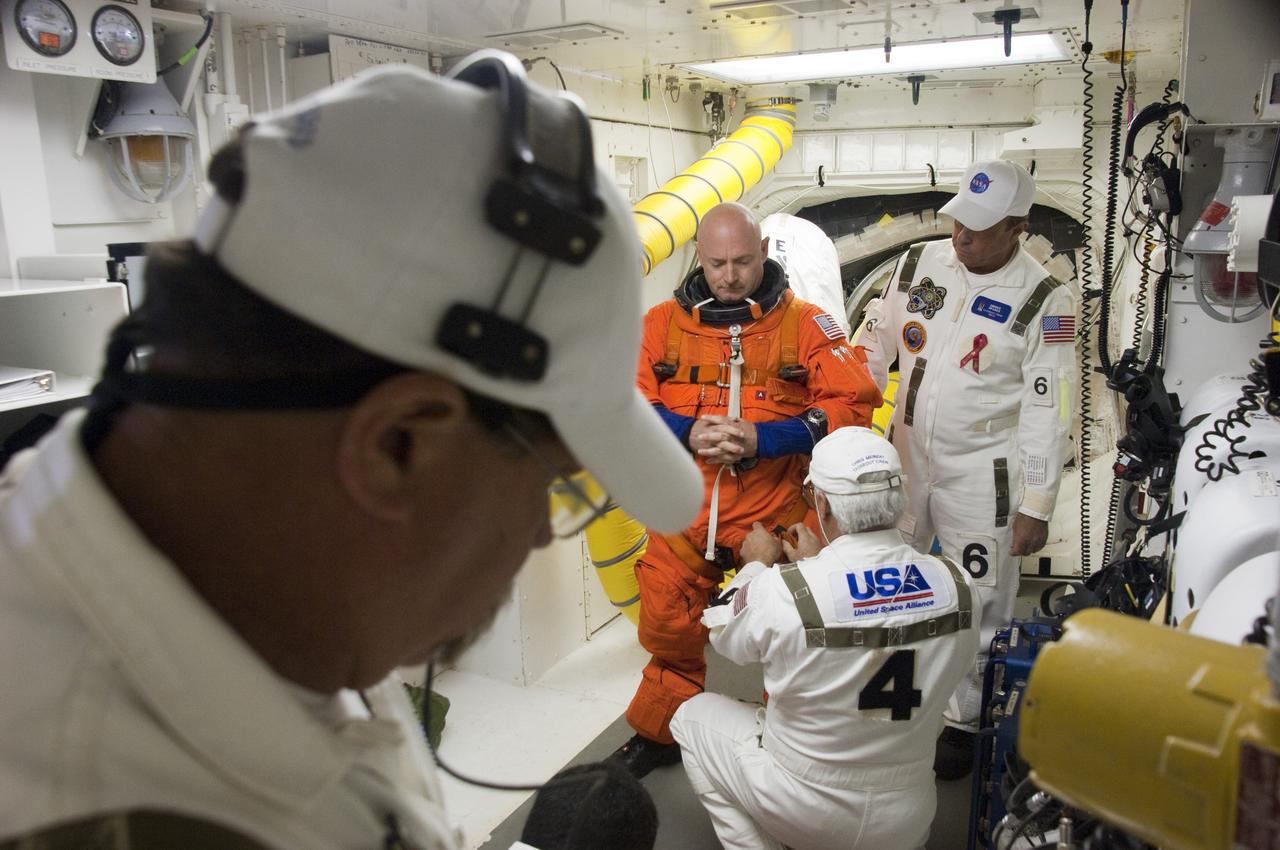 CAPE CANAVERAL, Fla. -- In the White Room at Launch Pad 39A at NASA's Kennedy Space Center in Florida, the Closeout Crew helps STS-134 Commander Mark Kelly put on the parachute for his launch-and-entry suit before he boards space shuttle Endeavour through the crew hatch in the background. Kelly last commanded space shuttle Discovery during its STS-124 mission in 2008.       STS-134 will deliver the Alpha Magnetic Spectrometer-2 (AMS), Express Logistics Carrier-3, a high-pressure gas tank and additional spare parts for the Dextre robotic helper to the International Space Station. May 16 at 8:56 a.m. will be the second launch attempt for Endeavour. The first attempt on April 29 was scrubbed because of an issue associated with a faulty power distribution box called the aft load control assembly-2 (ALCA-2). STS-134 will be the final spaceflight for Endeavour. For more information visit, www.nasa.gov/mission_pages/shuttle/shuttlemissions/sts134/index.html. Photo credit: NASA/Sandra Joseph and Kevin O'Connell