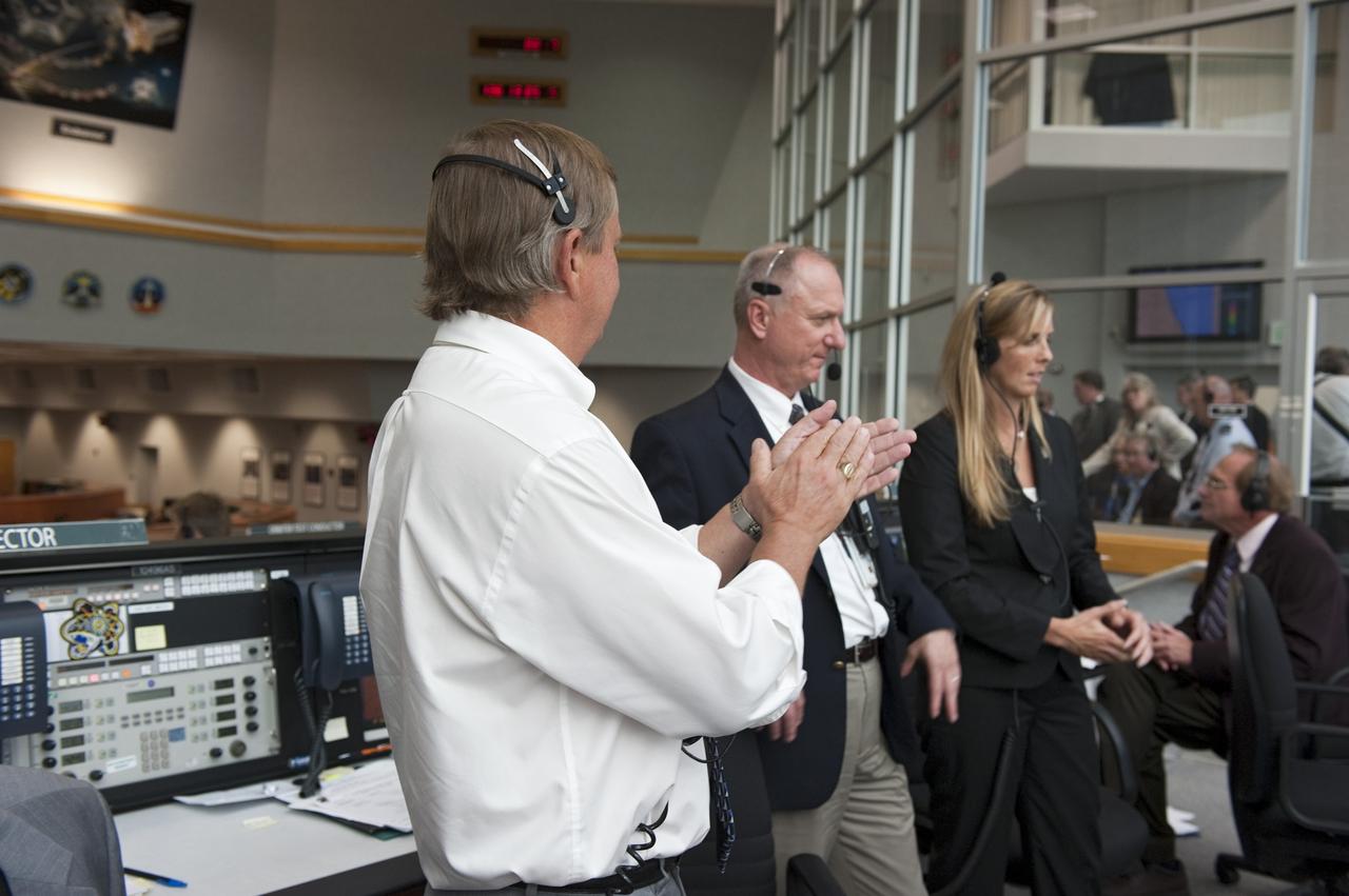 CAPE CANAVERAL, Fla. - Shuttle Launch Director Mike Leinbach, left, STS-134 Assistant Launch Director Pete Nickolenko and Endeavour's NASA Flow Director Dana Hutcherson give a round of applause to the launch controllers in Firing Room 4 of the Launch Control Center at NASA's Kennedy Space Center in Florida. Endeavour lifted off on its STS-134 mission to the International Space Station on time at 8:56 a.m. EDT on May 16.    The shuttle and its six-member crew are embarking on a mission to deliver the Alpha Magnetic Spectrometer-2 (AMS), Express Logistics Carrier-3, a high-pressure gas tank and additional spare parts for the Dextre robotic helper to the space station. Endeavour's first launch attempt on April 29 was scrubbed because of an issue associated with a faulty power distribution box called the aft load control assembly-2 (ALCA-2). For more information visit, www.nasa.gov/mission_pages/shuttle/shuttlemissions/sts134/index.html. Photo credit: NASA/Kim Shiflett