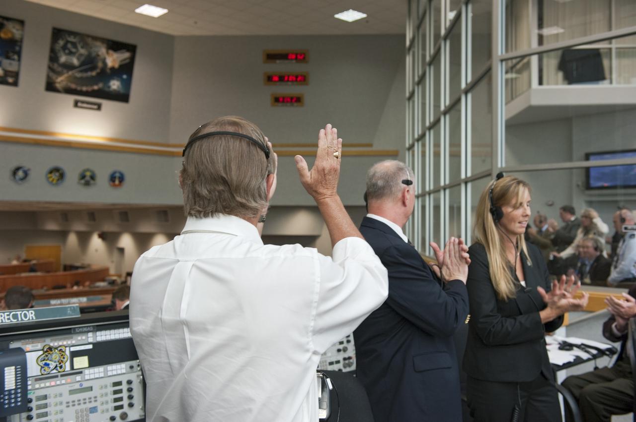 CAPE CANAVERAL, Fla. - Shuttle Launch Director Mike Leinbach, left, STS-134 Assistant Launch Director Pete Nickolenko and Endeavour's NASA Flow Director Dana Hutcherson give a round of applause to the launch controllers in Firing Room 4 of the Launch Control Center at NASA's Kennedy Space Center in Florida. Endeavour lifted off on its STS-134 mission to the International Space Station on time at 8:56 a.m. EDT on May 16.    The shuttle and its six-member crew are embarking on a mission to deliver the Alpha Magnetic Spectrometer-2 (AMS), Express Logistics Carrier-3, a high-pressure gas tank and additional spare parts for the Dextre robotic helper to the space station. Endeavour's first launch attempt on April 29 was scrubbed because of an issue associated with a faulty power distribution box called the aft load control assembly-2 (ALCA-2). For more information visit, www.nasa.gov/mission_pages/shuttle/shuttlemissions/sts134/index.html. Photo credit: NASA/Kim Shiflett