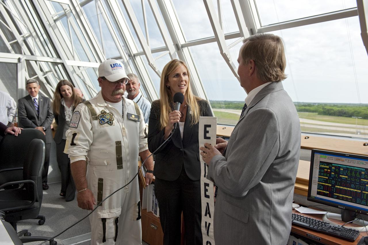 CAPE CANAVERAL, Fla. - Following a successful launch, space shuttle Endeavour NASA Flow Director Dana Hutcherson congratulates Shuttle Launch Director Mike Leinbach, right, and Closeout Crew Lead Travis Thompson in Firing Room 4 of the Launch Control Center at NASA's Kennedy Space Center in Florida. Endeavour lifted off on its STS-134 mission to the International Space Station on time at 8:56 a.m. EDT on May 16.    The shuttle and its six-member crew are embarking on a mission to deliver the Alpha Magnetic Spectrometer-2 (AMS), Express Logistics Carrier-3, a high-pressure gas tank and additional spare parts for the Dextre robotic helper to the space station. Endeavour's first launch attempt on April 29 was scrubbed because of an issue associated with a faulty power distribution box called the aft load control assembly-2 (ALCA-2). For more information visit, www.nasa.gov/mission_pages/shuttle/shuttlemissions/sts134/index.html. Photo credit: NASA/Kim Shiflett